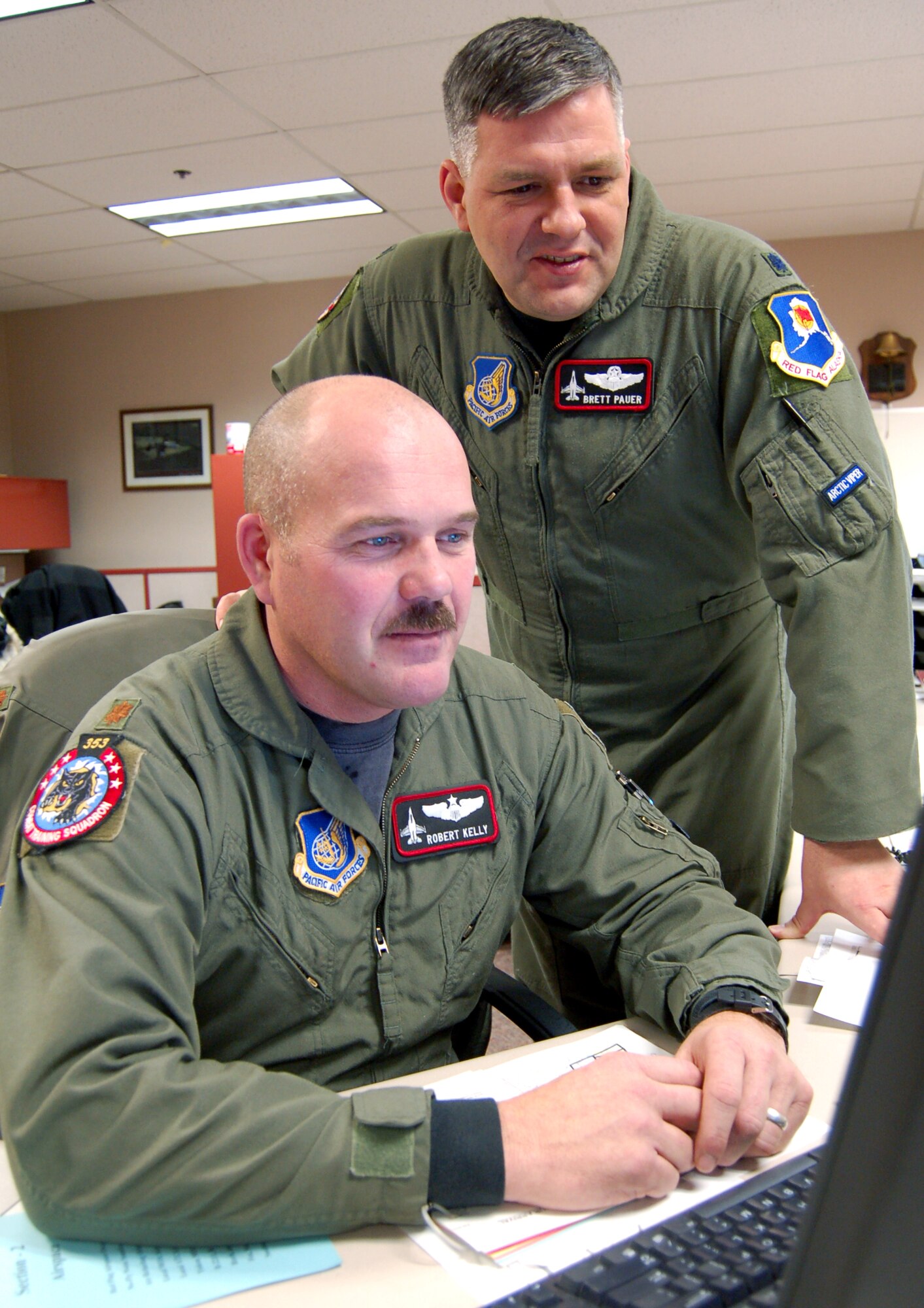 Maj. Robert Kelly (front) goes over operational mission plans for an upcoming Red Flag-Alaska exercise with Lt. Col. Brett Pauer, director of operations at the 353rd Combat Training Squadron at Eielson Air Force Base, Alaska. Eielson's exercise role is transitioning from Cope Thunder exercises to Red Flag-Alaska. Major Kelly is a weapons officer at the 353rd CTS and soon will be an aggressor pilot for the Red Forces during Red Flag-Alaska exercises. (U.S. Air Force photo/Staff Sgt. Matthew Rosine) 