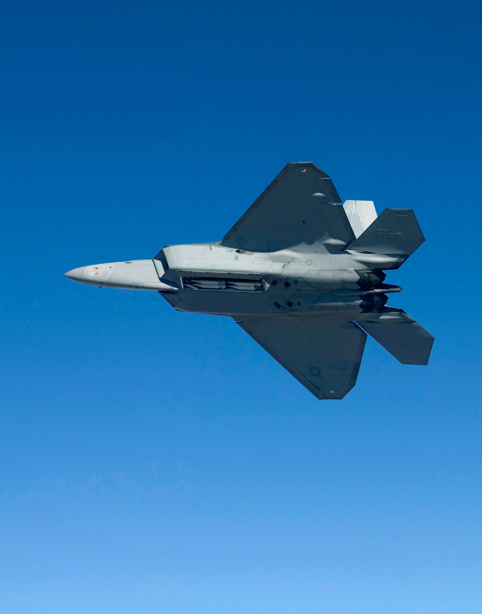 An F-22A Raptor flies Feb. 2, 2007, with four Small Diameter Bombs on board. Pilots and engineers from the F-22 Combined Test Force were performing load tests to ensure the GBU-39/B Small Diameter Bomb system does not exceed structural load boundaries for the Raptor. (Photo by Darin Russell)