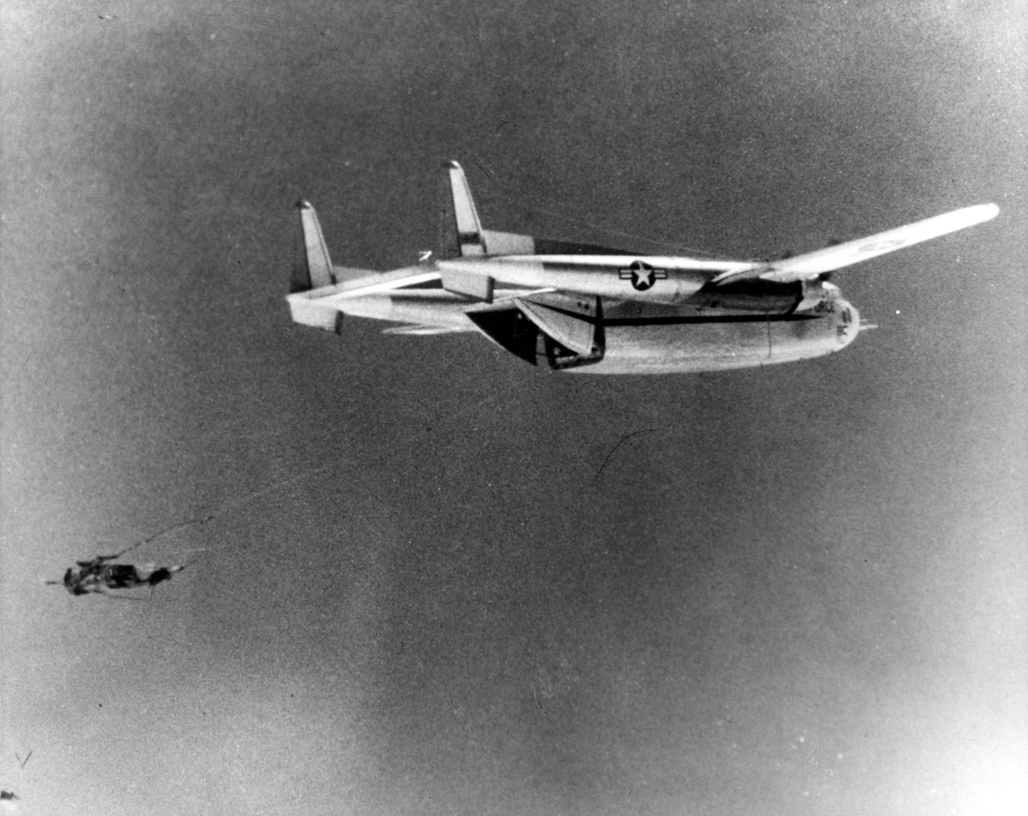 A Discoverer capsule being retireved during descent by a C-119. (U.S. Air Force photo)