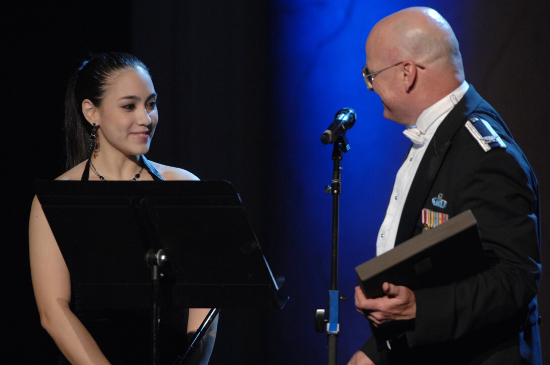Betty Macias receives a plaque of appreciation from Col. Dennis Layendecker, U.S. Air Force Band commander and conductor, after her performance at the Guest Artist Series concert at the Daughters of the American Revolution Hall in Washington March 4. Ms. Macias was the 2007 winner of the Col George S. Howard Young Artist competition. (U.S. Air Force photo by Airman 1st Class Timothy Chacon)