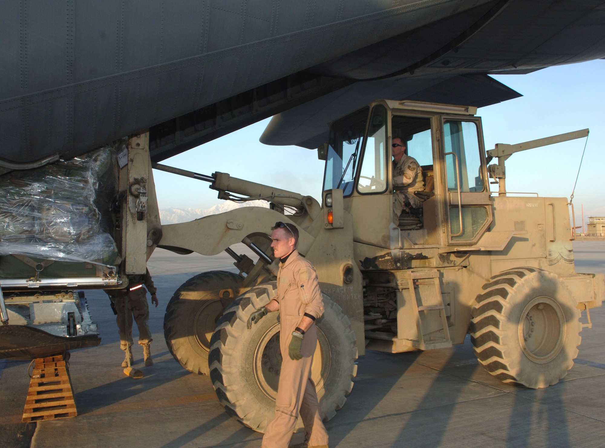 Tech. Sgt. Matthew Lamonds directs Staff Sgt. Brian Eck as he places a cargo pallet into a C-130 Hercules.  The C-130 provides tactical airlift for Operation Enduring Freedom.  Sergeant Lamonds is a loadmaster assigned to the 774th Expeditionary Airlift Squadron, and Sergeant Eck is part of the 455th Expeditionary Logistics Readiness Squadron. (U.S. Air Force photo/Staff Sgt. Kevin Tomko) 