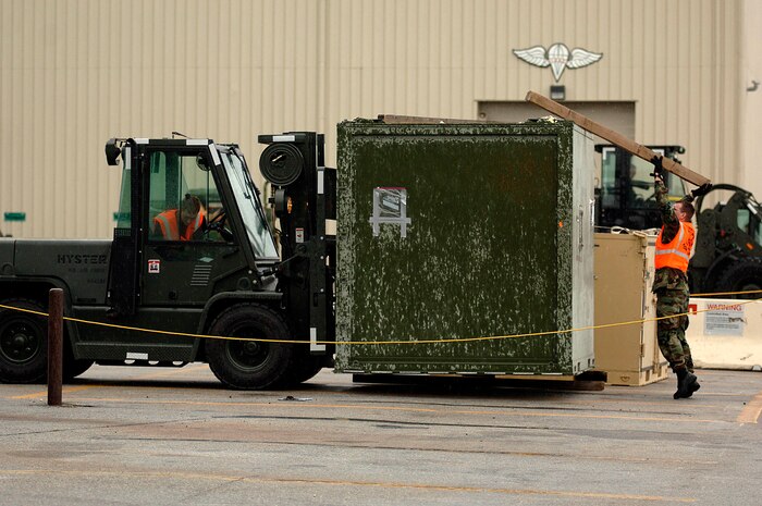 Airman 1st Class Ronald Stafford and Staff Sgt. Ryan Moyer, both of the 437th Aerial Port Squadron, move a weapons case on the flightline during the exercise.(RELEASED)(U.S. Air Force Photo by Airman 1st Class Nicholas Pilch)