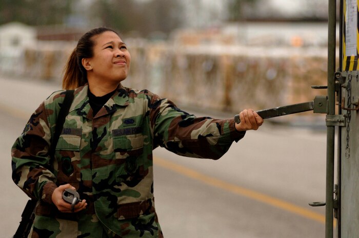 Staff Sgt. Desiree Yago, 437th Logistics Readiness Squadron security forces augmentee, opens a weapons case holding M-16 rifles on the flightline during the moblility exercise March 1. More than 600 Charleston Airmen went through the deployment line and 425 short tons of cargo were processed during the exercise. For more photos, see Page 5. (U.S. Air Force photo by Airman 1st Class Nicholas Pilch)