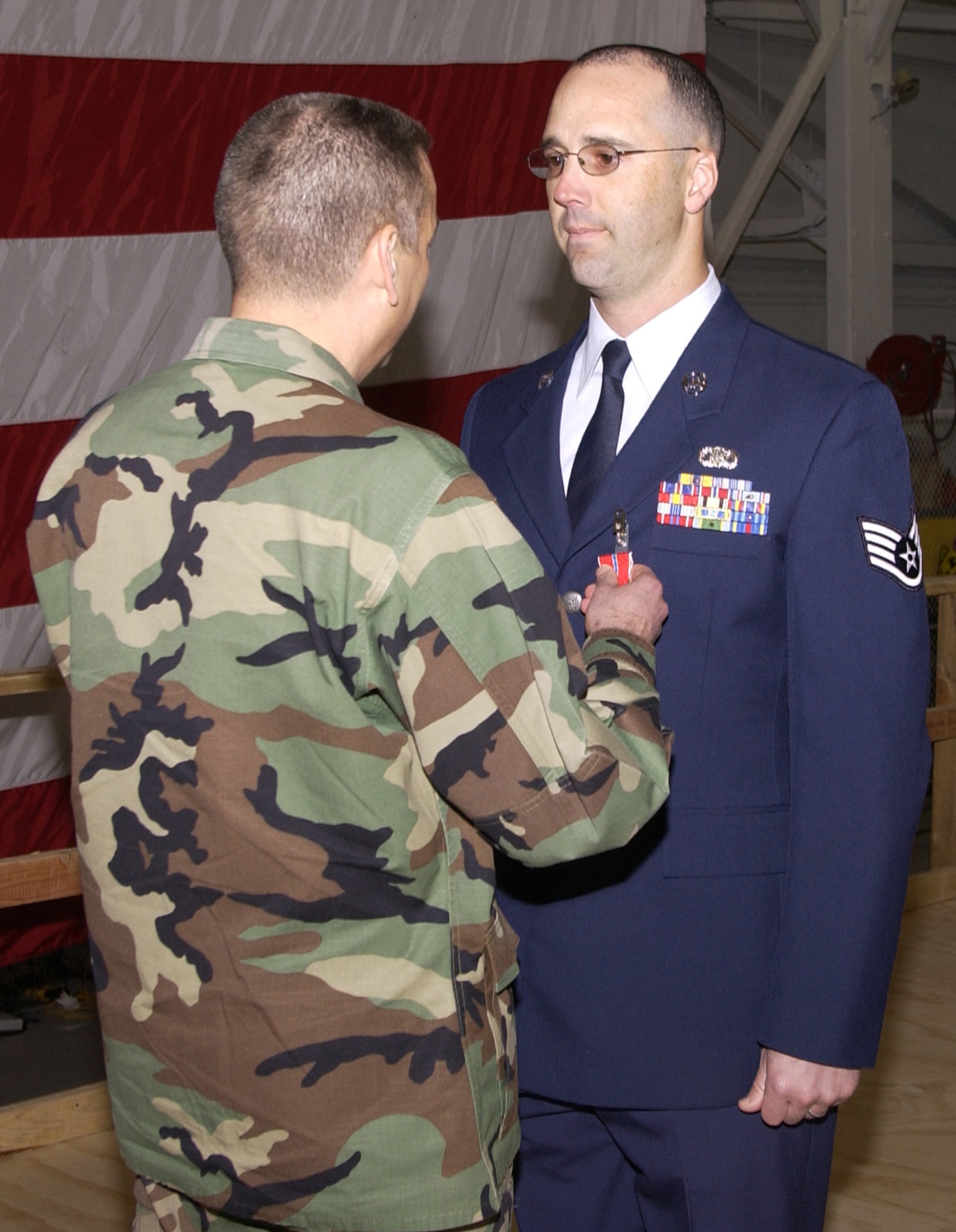Col. Jack Weinstein, former 30th Space Wing commander, pins the Bronze Star on Staff Sgt. Shane Cronin, 30th Space Communications Squadron, on March 1 at Vandenberg.  Sergeant Cronin received the medal for his service in Iraq and was presented the medal at Colonel Weinstein's last commander's call. (Photo by Airman 1st Class Robert Lewis)                              