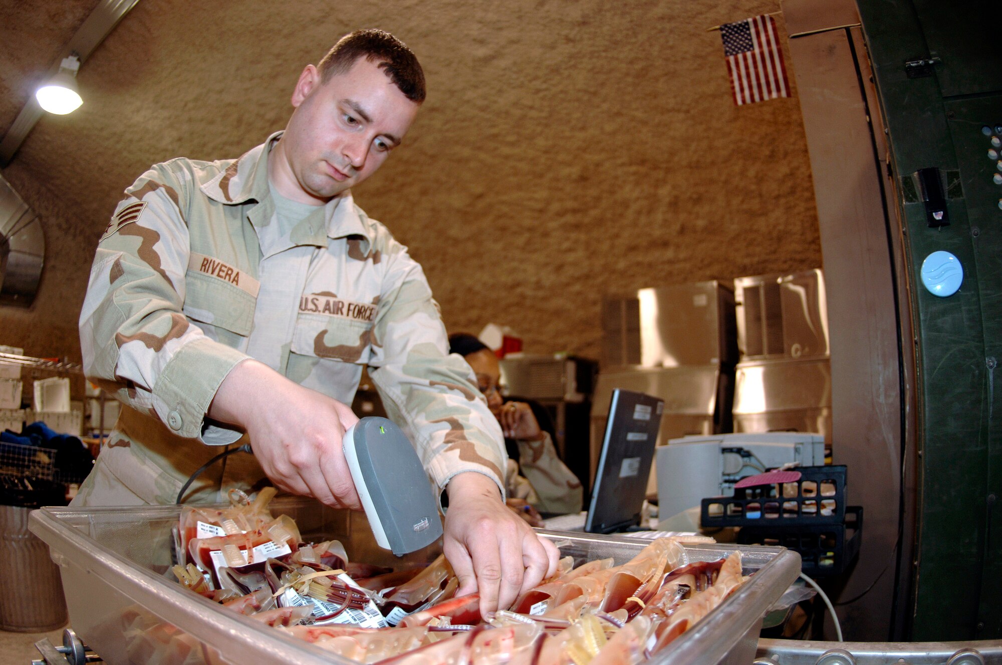 Senior Airman Samuel Rivera scans blood into a database which designates which forward blood supply unit in the area of responsibility will receive it. Airman Rivera is an administration technician assigned to the 379th Expeditionary Medical Group Blood Transshipment Center in Southwest Asia. (U.S. Air Force photo/Staff Sgt. David Miller) 
