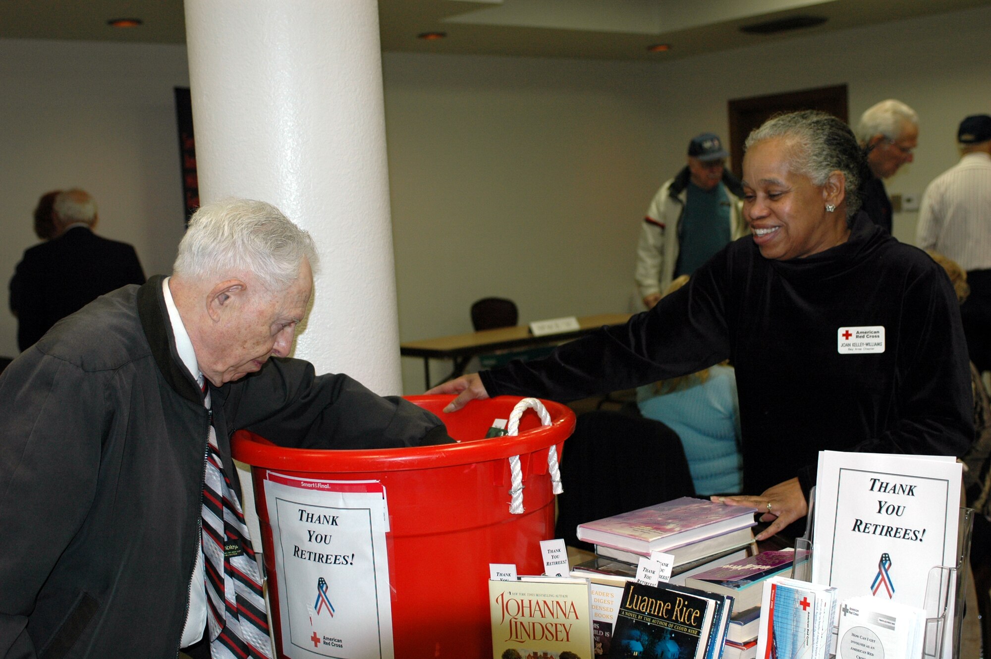 Mrs. Joan Kelley-Williams, David Grant USAF Medical Center’s American Red Cross station manager, assists Master Sgt. (retired) Joe Rowan find reading material during Retiree Appreciation Day at the Travis Conference Center March 3. Approximately 300 retirees attended the event, designed to honor and thank the men and women who live in the local community who previously served in the military. The event included free medical screenings and a tour of a C-17 Globemaster III. (U.S. Air Force photo by Staff Sgt. Candy Knight)