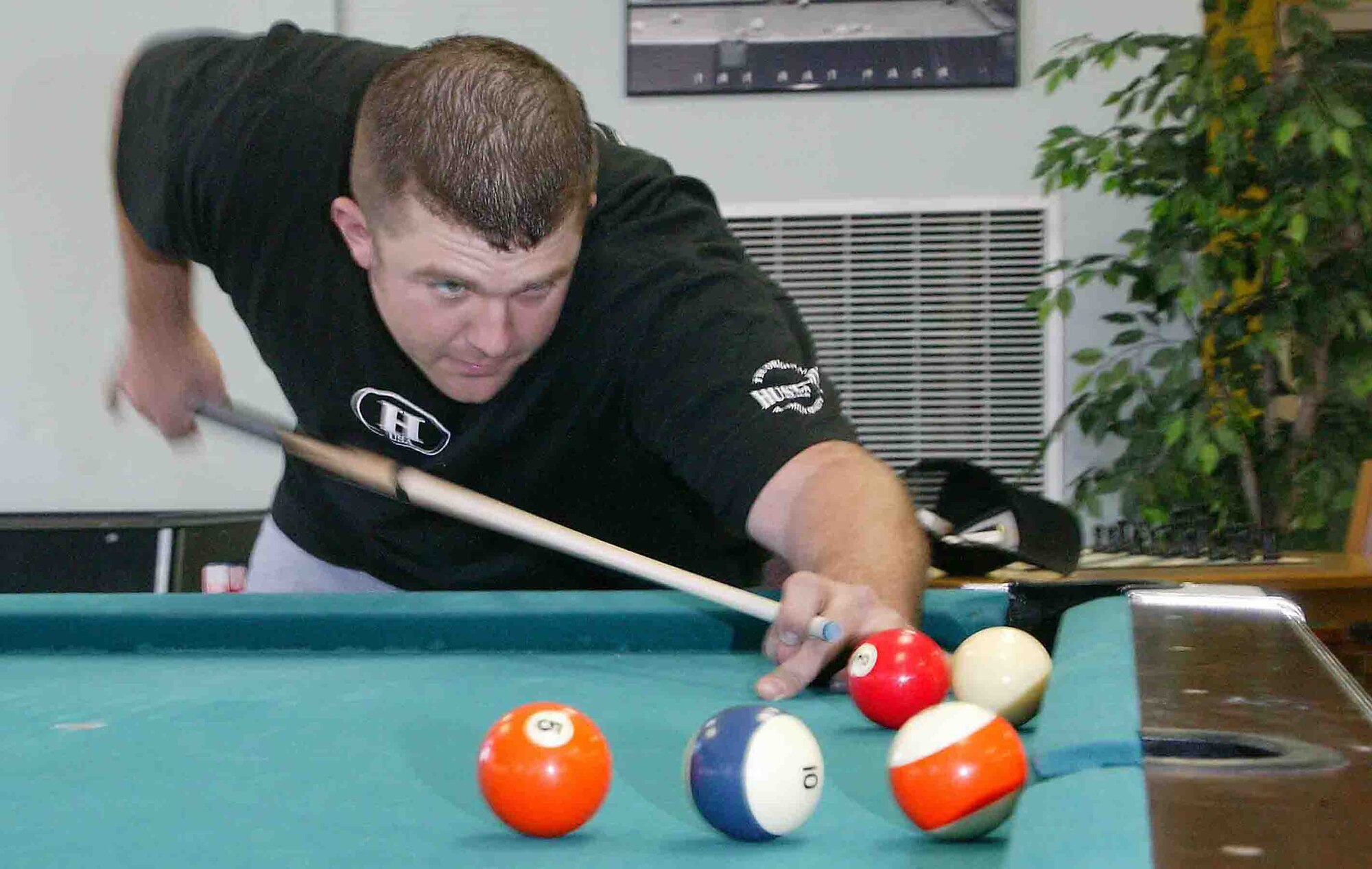 SHAW AIR FORCE BASE, S.C. -- Senior Airman Eric Charlton, 20th Civil Engineer Squadron Explosive Ordnance Disposal technician, performs a trick shot March 5 at the community center. Airman Charlton played the top players from all over the world and won 9th place as well as $500 at the National 9-Ball Bar Table Pool Tournament in Reno, Nev., from Feb. 28 to 30. Airman Charlton said 9th is the best he has ever placed in a national tournament. He competed against 145 people and won seven matches in a row to further himself to victory when he lost against Kim Davenport who plays on the U.S.A. pool team. (U.S. Air Force photo/Senior Airman John Gordinier)