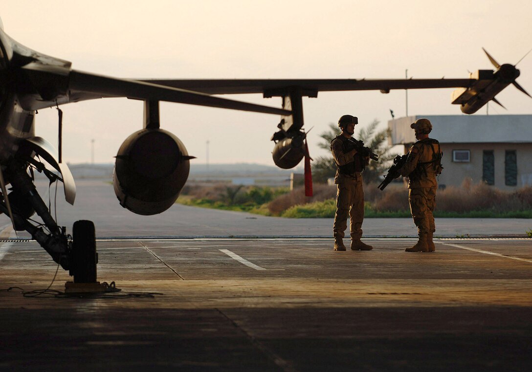 U.S. Air Force Staff Sgt. Lawrence Reents and Airman 1st Class Sean Stanton perform a walking patrol near an F-16 Fighting Falcon hazardous aircraft shelter, Feb. 16, 2007, at Balad Air Base, Iraq. Balad security forces patrol the airfield to gain a closer perspective of equipment and personnel.