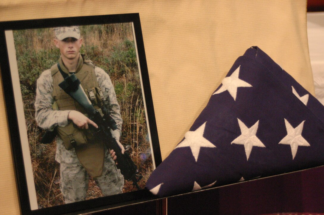 MARINE CORPS BASE CAMP LEJEUNE, N.C. (March 8, 2007)- A photograph of Pfc. Joshua A. Bailey sits next to a folded American flag during a memorial ceremony here March 8. Bailey, a Vinemont, Ala., native, was died on Feb. 21 from injuries sustained during a training event aboard the base. He was an automotive mechanic with Battery T, 5th Battalion, 10th Marines Regiment. He was 18-years-old. (Official U.S. Marine Corps photo by Cpl. Lucian Friel (RELEASED)