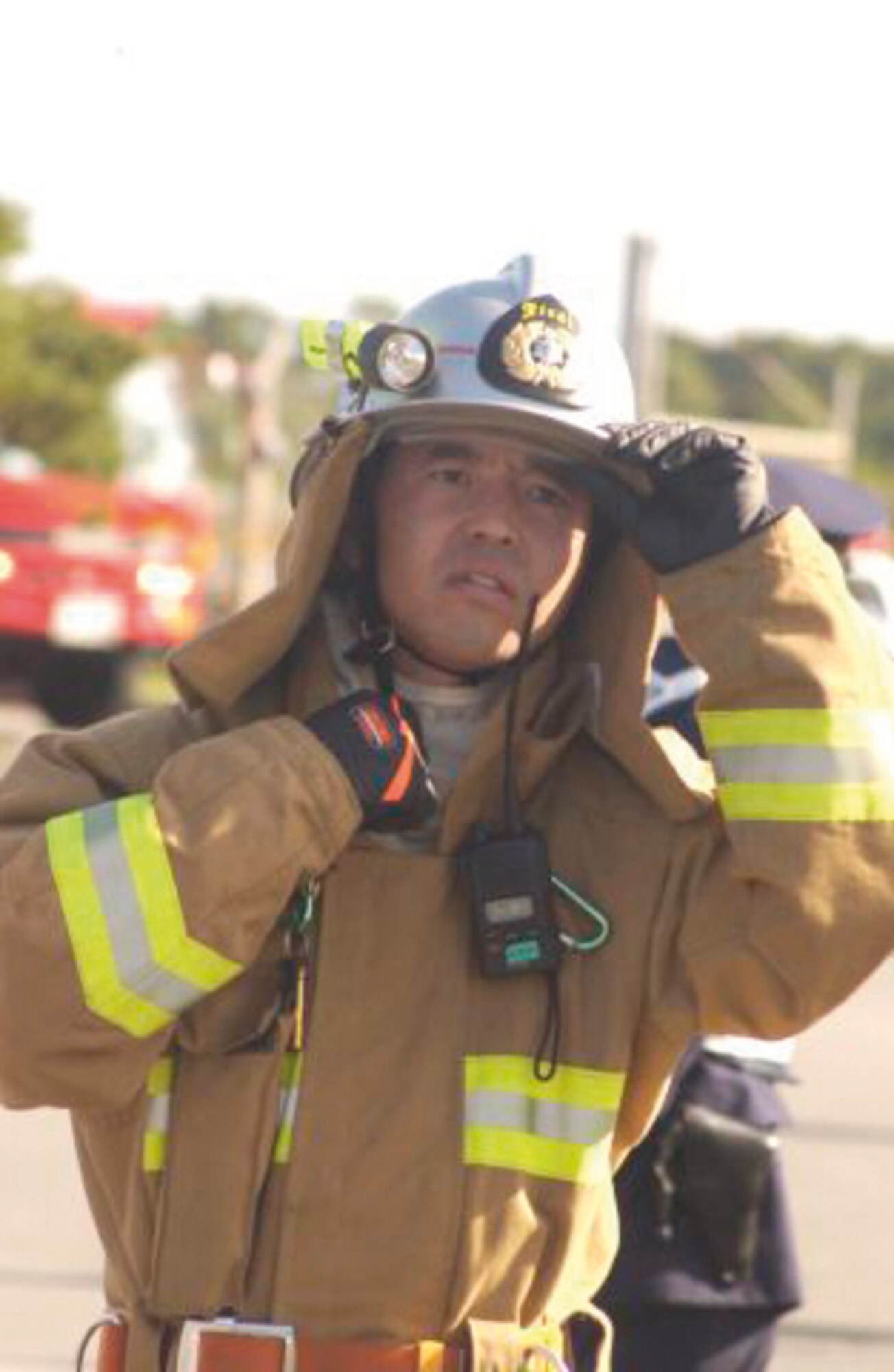A crew chief form the local Japanese fire department seveys the are to ensure the safty of his crew members during the first bilateral off-base exercise Feb. 28, 2007, between Kadena Air Base emergency responders and local Okinawan police, fire and medical teams. The exercise was conducted to enhance cooperation between base and off-base agencies in the event of an aircraft accident.