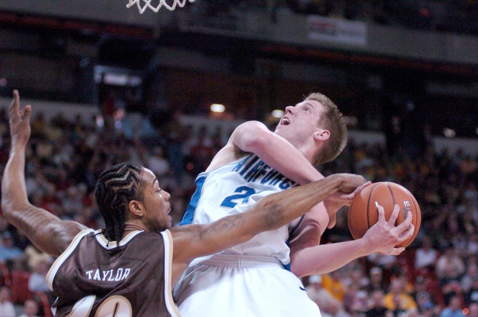 Air Force forward Jacob Burtschi is fouled by Wyoming forward Joseph Taylor as he attempts a lay up in their quarterfinal game at the Mountain West Conference tournament in Las Vegas Thursday, March 8. Nationally ranked nearly the entire season, the Falcons were eliminated in their first game of the tourney, 67-62. Air Force now has an all-time record of 0-8 in the MWC tournament. (U.S. Air Force photo/1Lt John Ross)