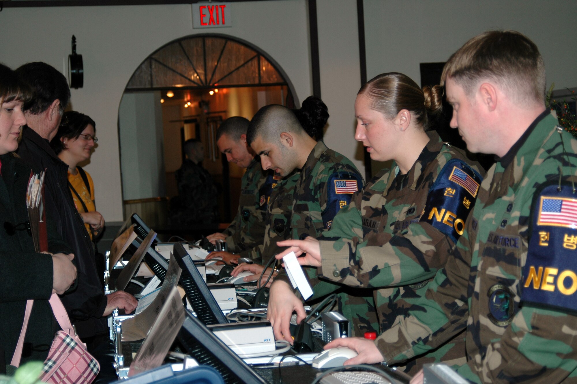 OSAN AIR BASE, Republic of Korea --  Members of the Non-combatant Processing Team register participants into the non-combatant evacuation operation database and issue wristbands so they can begin their journey through the processing line. NPT processed more than 1,500 non-combatants for the 2007 NEO Operational Readiness Inspection Tuesday and Wednesday. (U.S. Air Force photo by Master Sgt. Steven Goetsch)