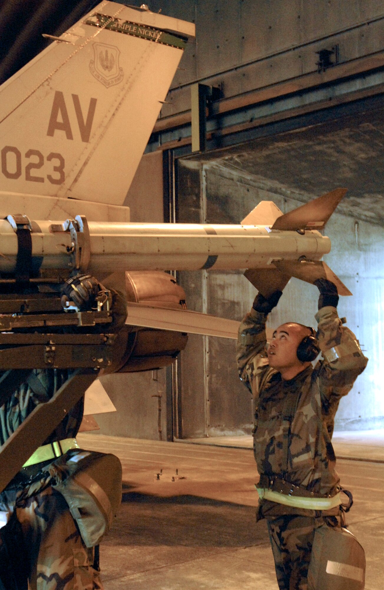 Staff Sgt. Joseph Sundita helps load a missile onto an F-16 Fighting Falcon March 8 during a NATO Tactical Evaluation at Aviano Air Base, Italy. The evaluation is to determine if Aviano's 31st Fighter Wing is prepared to support NATO Response Force 9/10.  Sergeant Sundita is with the 31st Aircraft Maintenance Squadron.  (U.S. Air Force photo/Airman 1st Class Liliana Moreno)