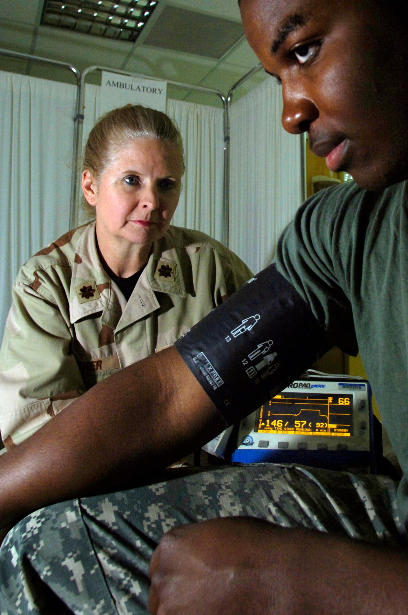 Major Laurie Turner takes Pfc. David Kendrick's blood pressure reading at Balad Air Base, Iraq. Major Turner is deployed from the 920th Aeromedical Staging Squadron at Patrick Air Force Base, Fla. Private Kendrick is deployed to Iraq from Fort Carson, Colo. (U.S. Air Force photo/Airman 1st Class Nathan Doza)
