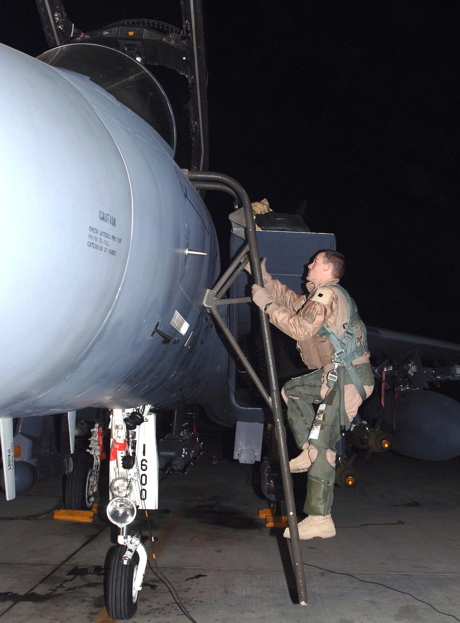 First Lt. Reid Sanborn climbs into the cockpit of an F-15E Strike Eagle before taking off under cover of darkness in Afghanistan this week. The F-15E has been instrumental in providing close-air support for coalition ground forces in the war on terrorism and more recently in Operation Achilles, an offensive launched this week by the International Security Assistance Force. (U.S. Air Force photo/Staff Sgt. Kevin Tomko)