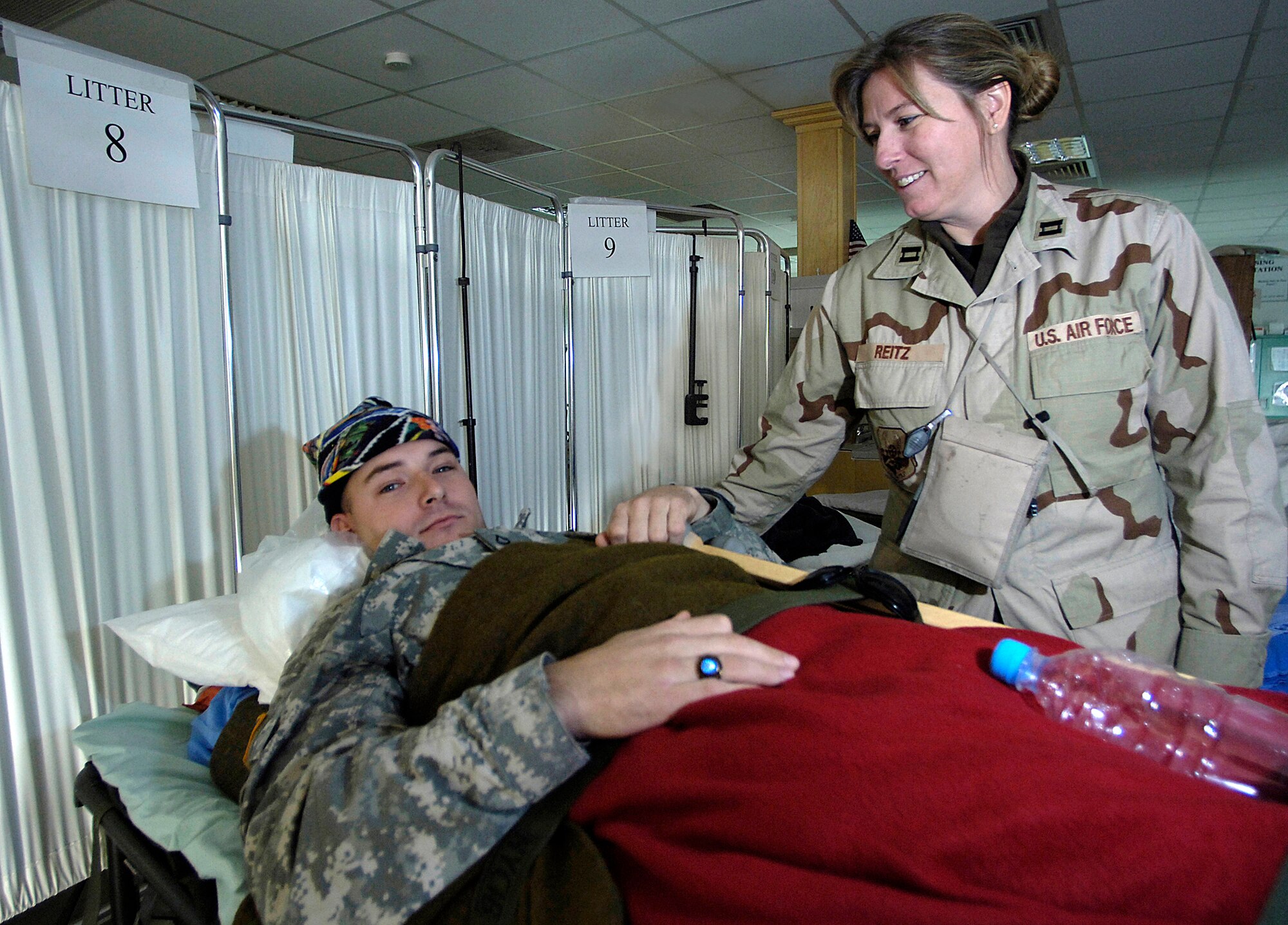 Captain Laura Reitz cares for Army National Guard Private 1st Class Tommy Fowler a wounded Soldier at the 332nd Contingency Aeromedical Staging Facility in Balad Air Base, Iraq. Captain Reitz is from the Air Force Reserve's 920th Aeromedical Staging Squadron at Patrick Air Force Base, Fla. She is also an open heart recovery nurse at the Holmes Regional Medical Center in Melbourne, Fla. Private Fowler is with the Delta Company, 2nd Battalion/124th Infantry. (U.S. Air Force photo/Airman 1st Class Nathan Doza) 

