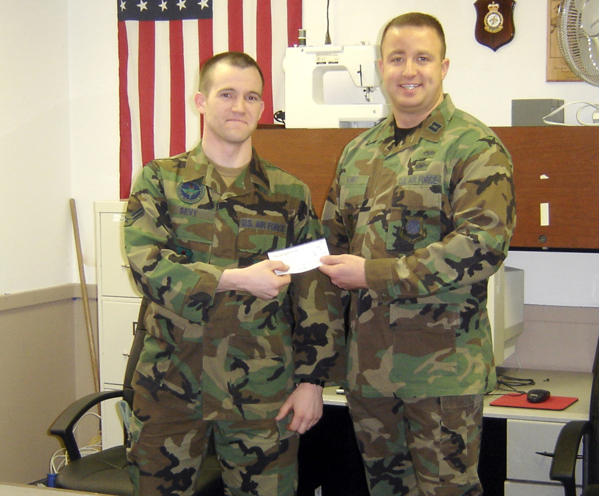 FAIRCHILD AIR FORCE BASE, Wash. -- Capt. Thomas Kubit, Company Grade Officer Council treasurer, presents Airman 1st Class Jacob Sevy, 22nd Training Squadron, with a $100 book grant Monday. The CGOC chose Airman Sevy from an essay he submitted about his education goals and personal experiences with furthering his education, and a command-written letter of recommendation. The CGOC awards two book grants each year; the second 2007 grant was awarded to Airman 1st Class Ashley Waller, 92nd Aeromedical Dental Squadron. (Photo by Leslie North)

