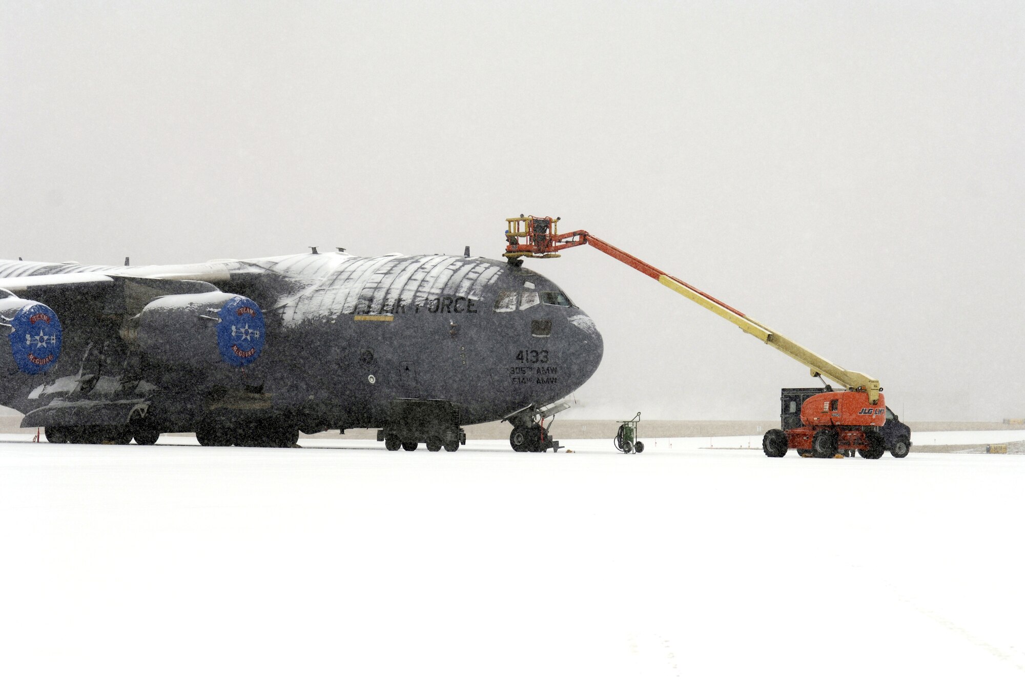 Airman Russell Baker, a fuel systems journeyman, sits atop a C-17 Globemaster III to work on the air-refueling receptacle March 7 during a snowstorm that  hit McGuire Air Force Base, N.J. Airman Baker is assigned to the 305th Maintenance Squadron. (U.S. Air Force photo/by Kenn Mann)