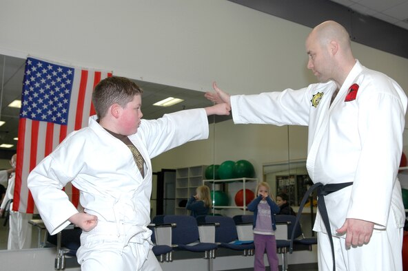 FAIRCHILD AIR FORCE BASE, Wash. -- Trevor Lynnes, son of Tech. Sgt. Douglas McDonald, 92nd Logistics Readiness Squadron, works on his Karate technique with Army Sgt. 1st Class Cris Henry, 3rd Battalion 415 Regiment first sergeant during a Shotokan Karate class Monday. The class, held 6-7:30 p.m. every Monday and Wednesday at the Fitness Center, is open to all military ID card holders age 7 and up. (Photo by Staff Sgt. Kristian Carter)
