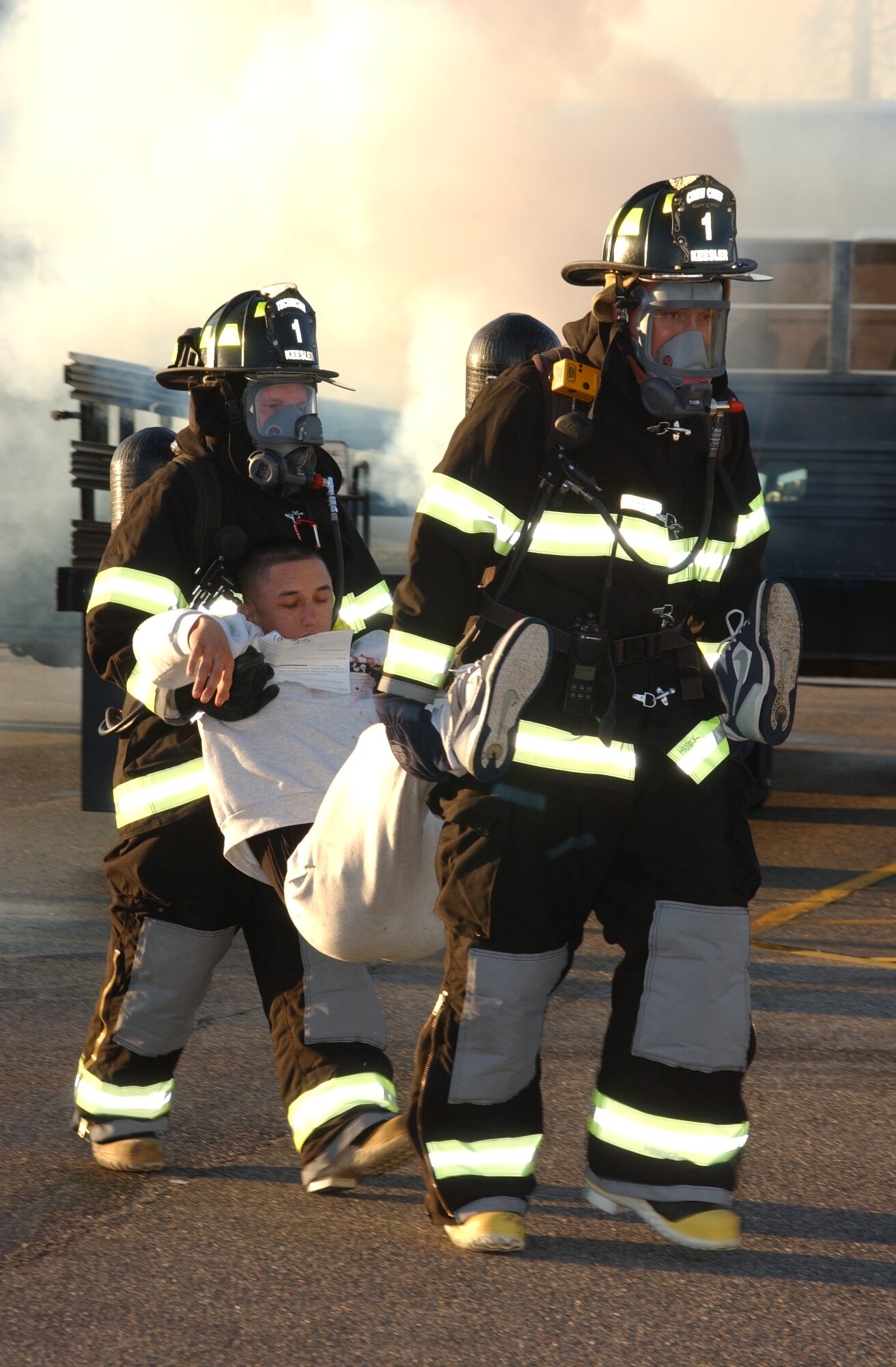 left, TSgt Jeffrey Zaleski, 81 Civil Engineer Squadron;  center, Airman Kyle Stewart, 334 Training Squadron student; right, SSgt Jason Haddock, 81 Civil Engineer Squadron.  The 2 firemen carry Stewart to a decontamination site, during a major accident response exercise today.  The exercise was designed to test Biloxi and Keesler Air Force Base first-responders' ability to work together.  (U.S. Air Force Photo by Kemberly Groue)
