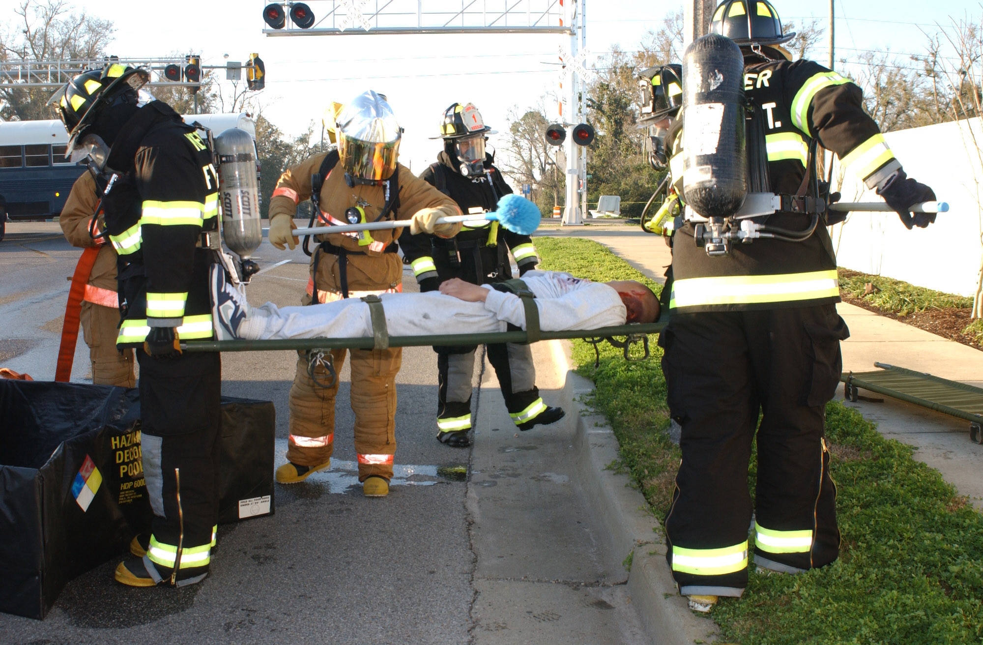 Left to right, Senior Airman Michael Kehoe, Airman Basic Shawn Edgecomb, Donavan Oosterhuis, civilian, and Staff Sergeant Timothy Hogan, all 81st Civil Engineer Squadron firefighters work together to decontaminate Airman Kyle Stewart, 334th Training Squadron student and injury volunteer, during a major accident response exercise held near the intersection of White Avenue and Irish Hill Rd.  The exercise tested Biloxi and Keesler Air Force Base first-responders' ability to work together in the event of a train derailment.  (U.S. Air Force Photo by Kemberly Groue)
