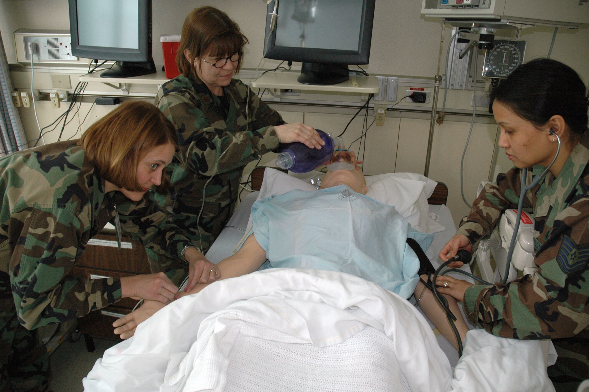 MINOT AIR FORCE BASE, N.D. -- From left: Lt. Colonel Jennifer Bauer, Maj. Ann Perry and Tech. Sgt. Rosita Dacpano, all from the 5th Medical Group, perform various medical procedures on the SimMan, a training dummy, at the 5th MDG March 1. A SimMan is a portable and advanced patient simulator for medical training. (U.S. Air Force photo by Airman 1st Class Wesley Wright) 