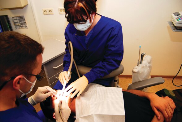 SPANGDAHLEM AIR BASE, GERMANY -- Birgit Thoemmes, 52nd Dental Squadron dental assistant, assists Dr. (Maj.) Brian Penton, 52nd DS dentist, with a filling March 1. The 52nd Dental Squadron celebrated National Dental Assistant Recognition Week March 5-9. The squadron officers provided prizes, certificates and an award luncheon to the entire staff. The events were designed to recognize the multitalented and versatile dental assistants and support personnel who facilitate and enhance the delivery of quality dental health care to the members of 52nd Fighter Wing. (US Air Force photo/Nick Anderson)
