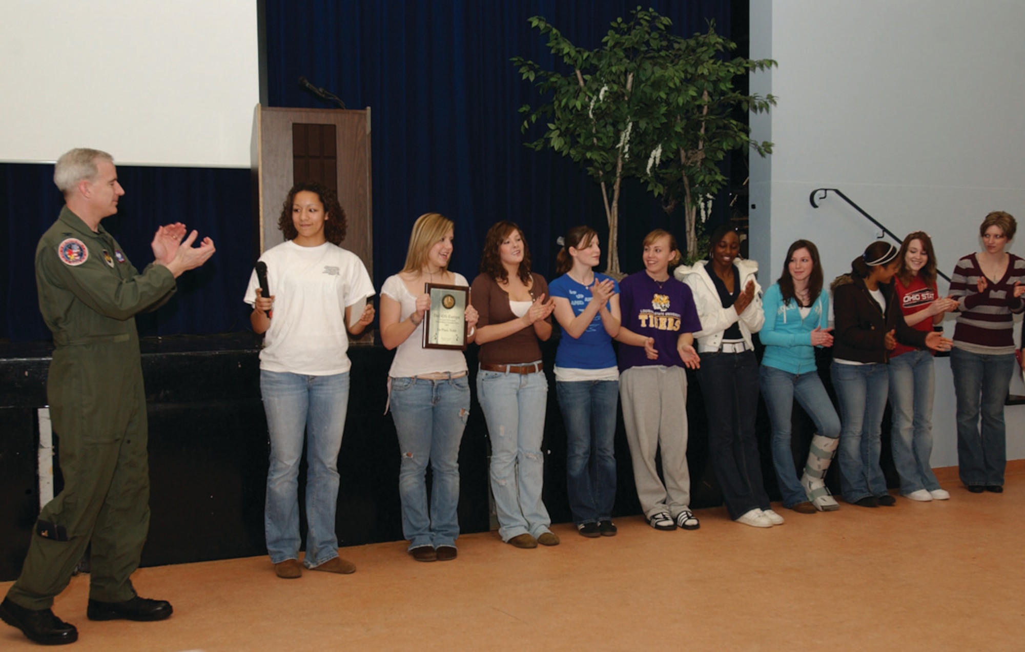 SPANGAHLEM AIR BASE, GERMANY -- Col. Thomas Feldhausen, 52nd Fighter Wing vice commander, presents Bitburg High School cheerleaders the Department of Defense Dependents Schools-Europe Division III Cheerleading Championship first place plaque March 6. This is the seventh year in a row the cheerleaders took home first place in the competition. (US Air Force photo/Airman 1st Class Emily Moore)