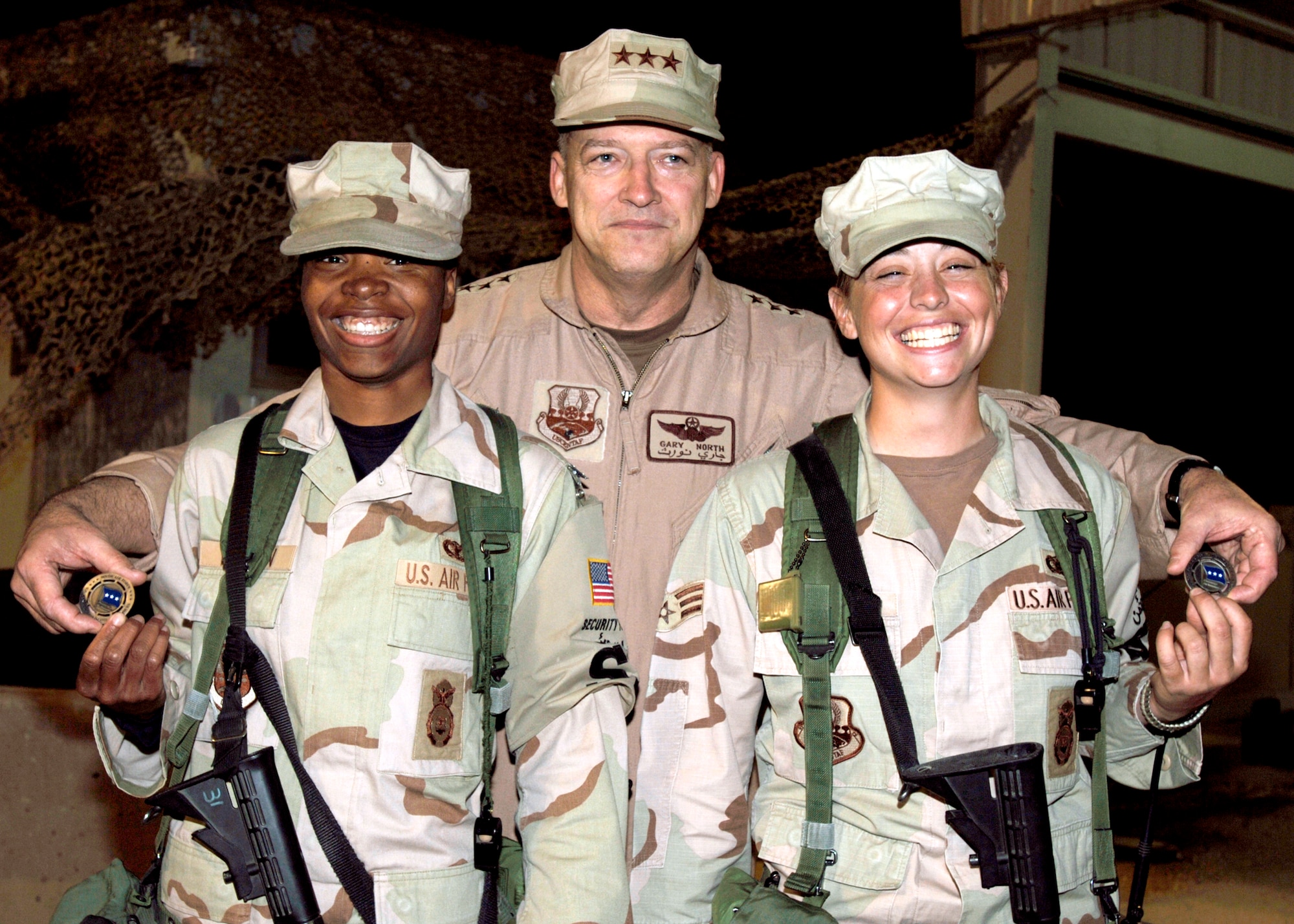SOUTHWEST ASIA -- Lt. Gen. Gary North poses with SrA. Lashonna Wooten and SrA. Valerie Ellis, 386 ESFS, after presenting the two with coins Feb. 17. The two Security Forces members delivered an excellant post brief to the General, which included the singing of the Air Force song. USAF Photo by TSgt Edward D. Holzapfel 