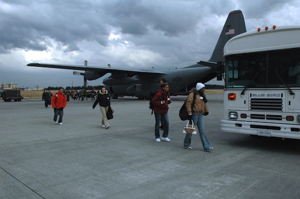 YOKOTA AIR BASE, Japan March 6, 2007 -- Members of the 8th Fighter Wing make their way from a C-130 to awaiting buses to inprocess at Yokota Air Base, Japan. The members, portraying non-combatants evacuating Korea, were part of the Wolf Pack?s NEO inspection March 6. 