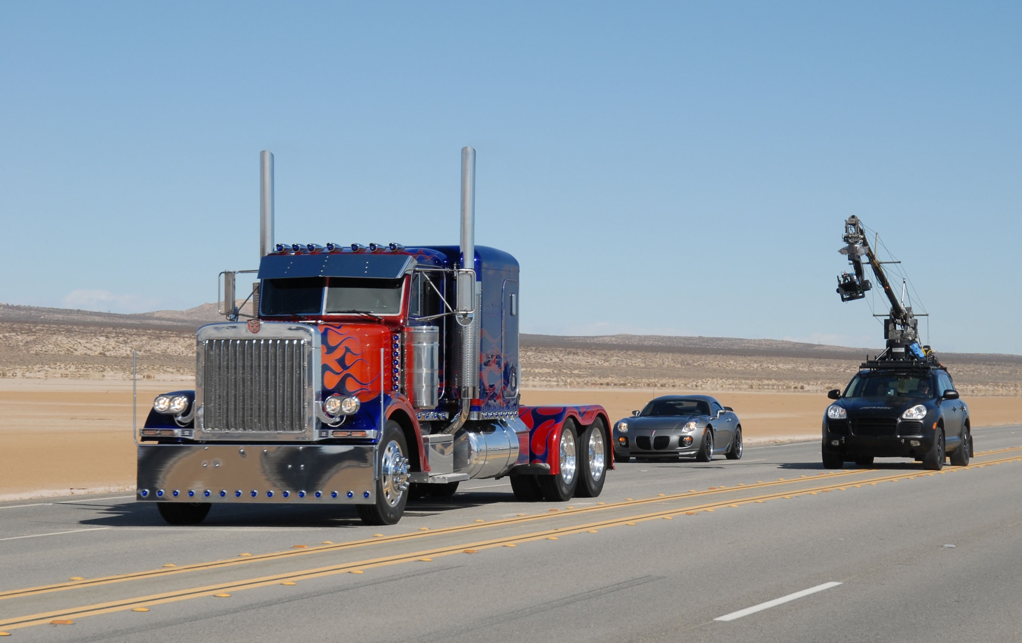 Two Transformers race down Rosamond Boulevard followed by a camera car during a film shoot here Feb. 28, 2007. This shoot marks the second and final round of on-base filming for the upcoming "Transformers" movie. (Photo by 1st Lt. Brad Kimberly)