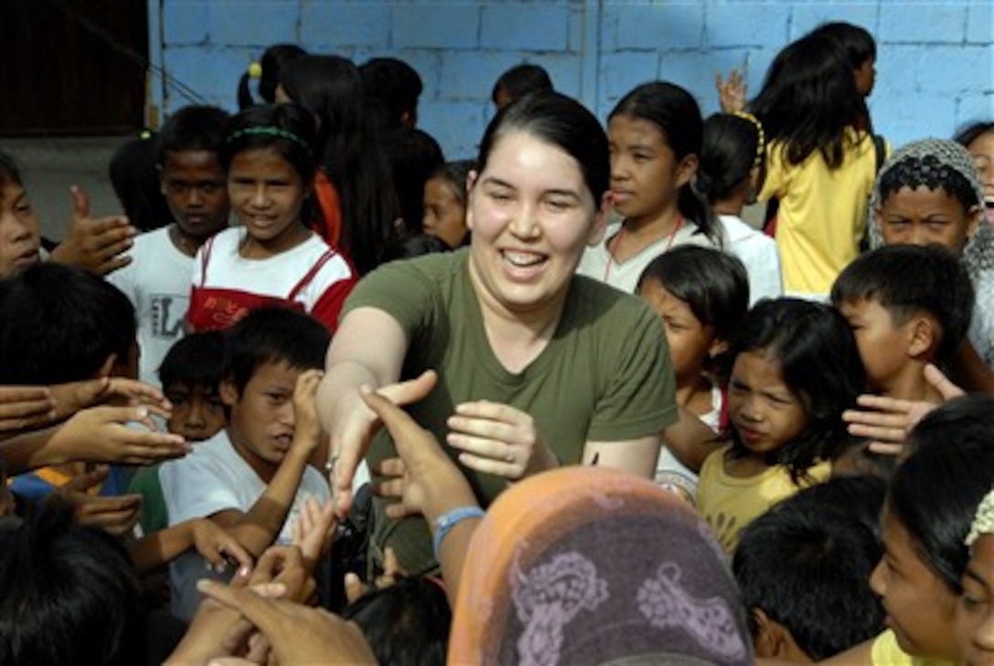U.S. Navy Petty Officer 3rd Class Nina Kovacs, assigned to the 3rd Medical Battalion, shakes the hands of local kids during a medical civic action program as part of exercise Balikatan 2007 at Lambayong, Sultan Kudarat, Philippines, Feb. 25, 2007.