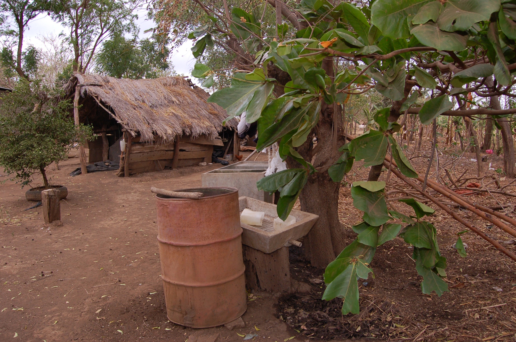 Luisa Palacio-Cortez, the 83-year-old woman whose house neighbors Camp Red Horse, washes clothes in this washbasin in the backyard. She said one of the her many family members who live in the cluster of houses on their property sleeps in the shed pictured here. (U.S. Air Force photo/Senior Airman Jacque Lickteig)