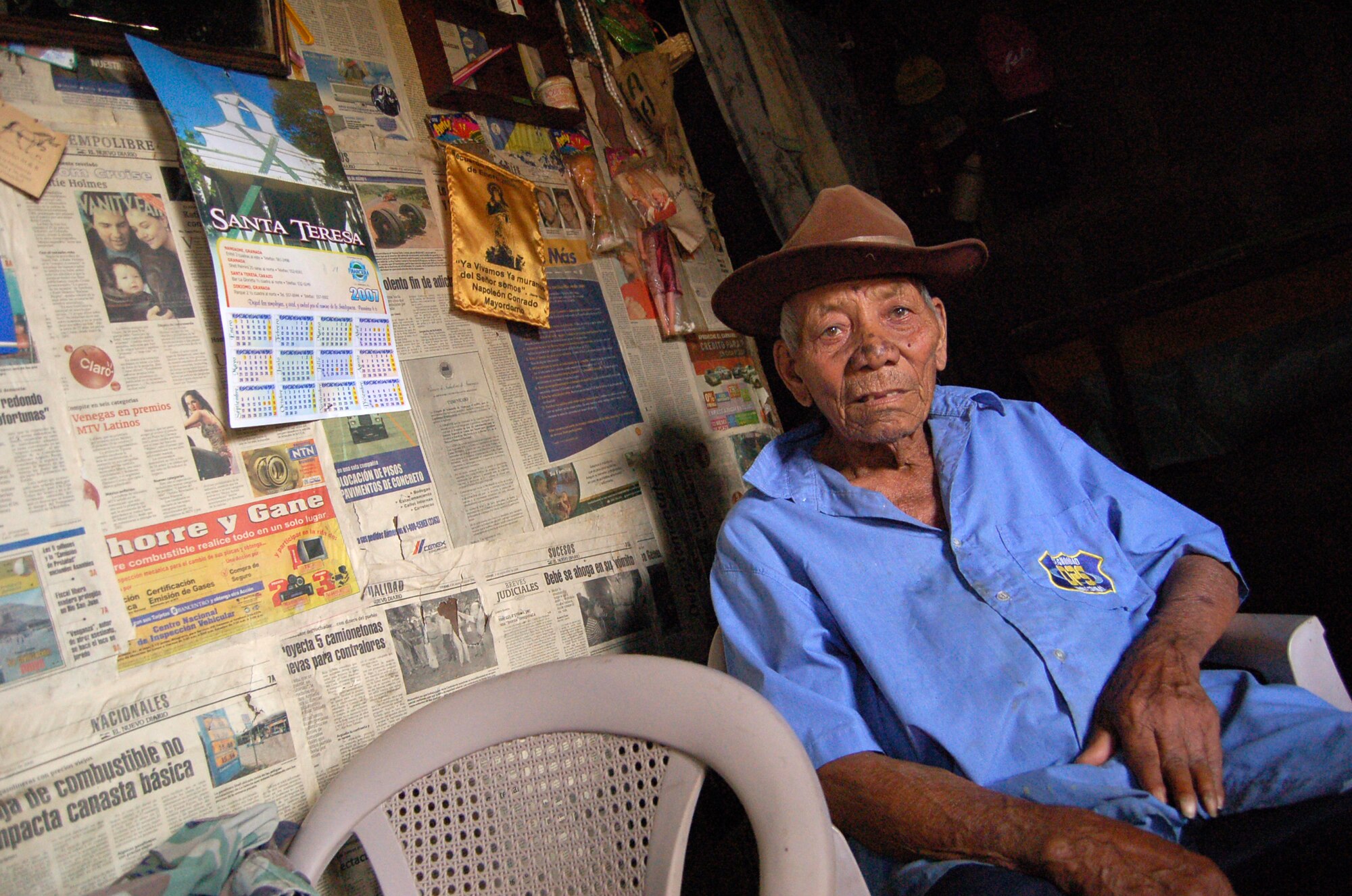 Selmo Cortez, Luisa Palacio-Cortez's husband, sits in one of three plastic chairs inside the front room of their two-room house. The front room is their living area, kitchen, storage room and sleeping area for two of their sons. The chairs are the only form of comfort in that room. (U.S. Air Force photo/Senior Airman Jacque Lickteig)