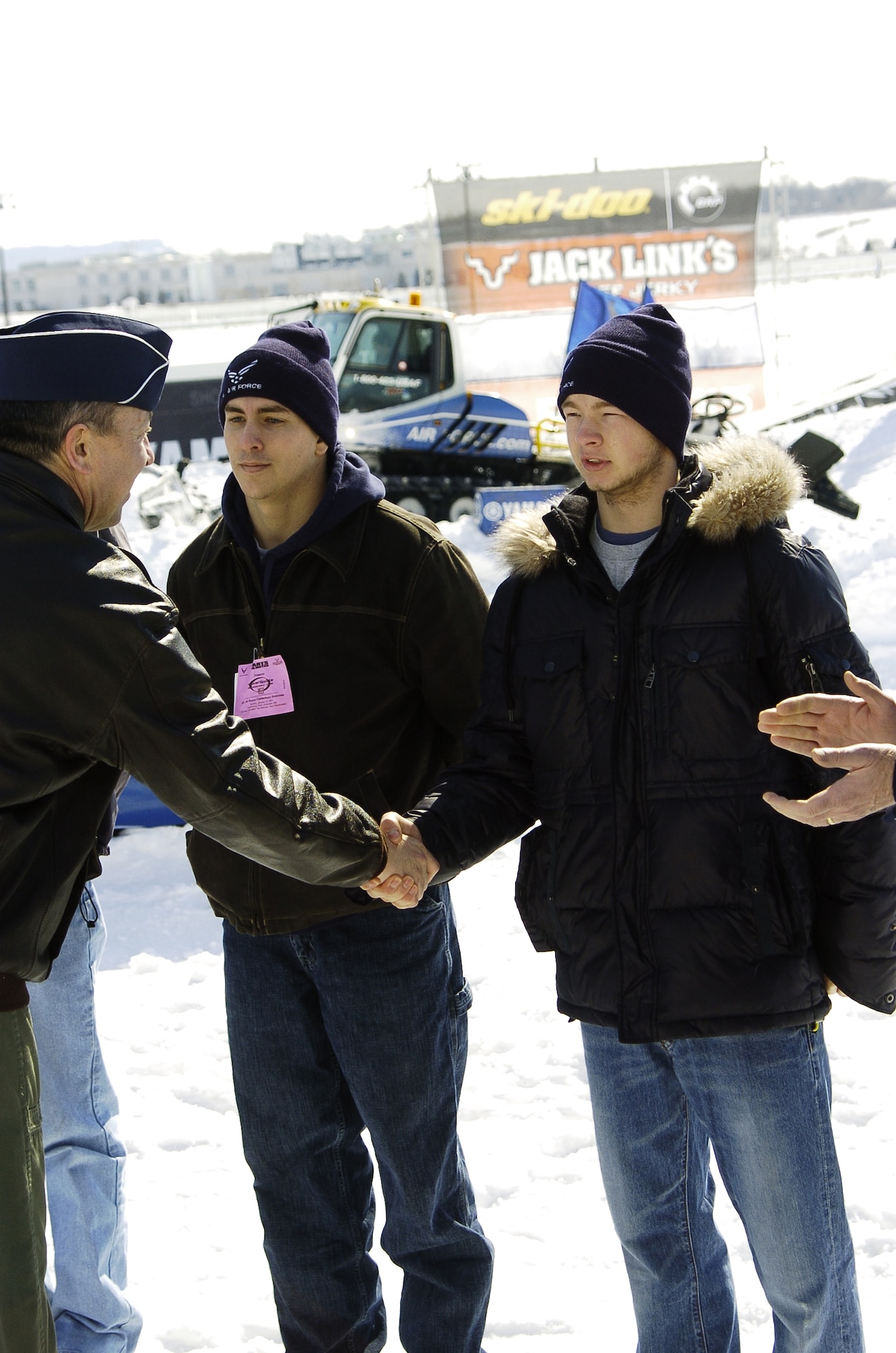 Brig. Gen. Gregory Feest, Deputy Director for Force Application, Directorate of Force Structure, Resources and Assessment, Joint Staff, Washington, D.C., congratulates Air Force Delayed Entry Program members following their oath of enlistment ceremony at the Air Force Canterbury Snocross event in Shakopee, Minnesota, March 4.  (Photo courtesy of Mike Roth, Maxim Graphics)
