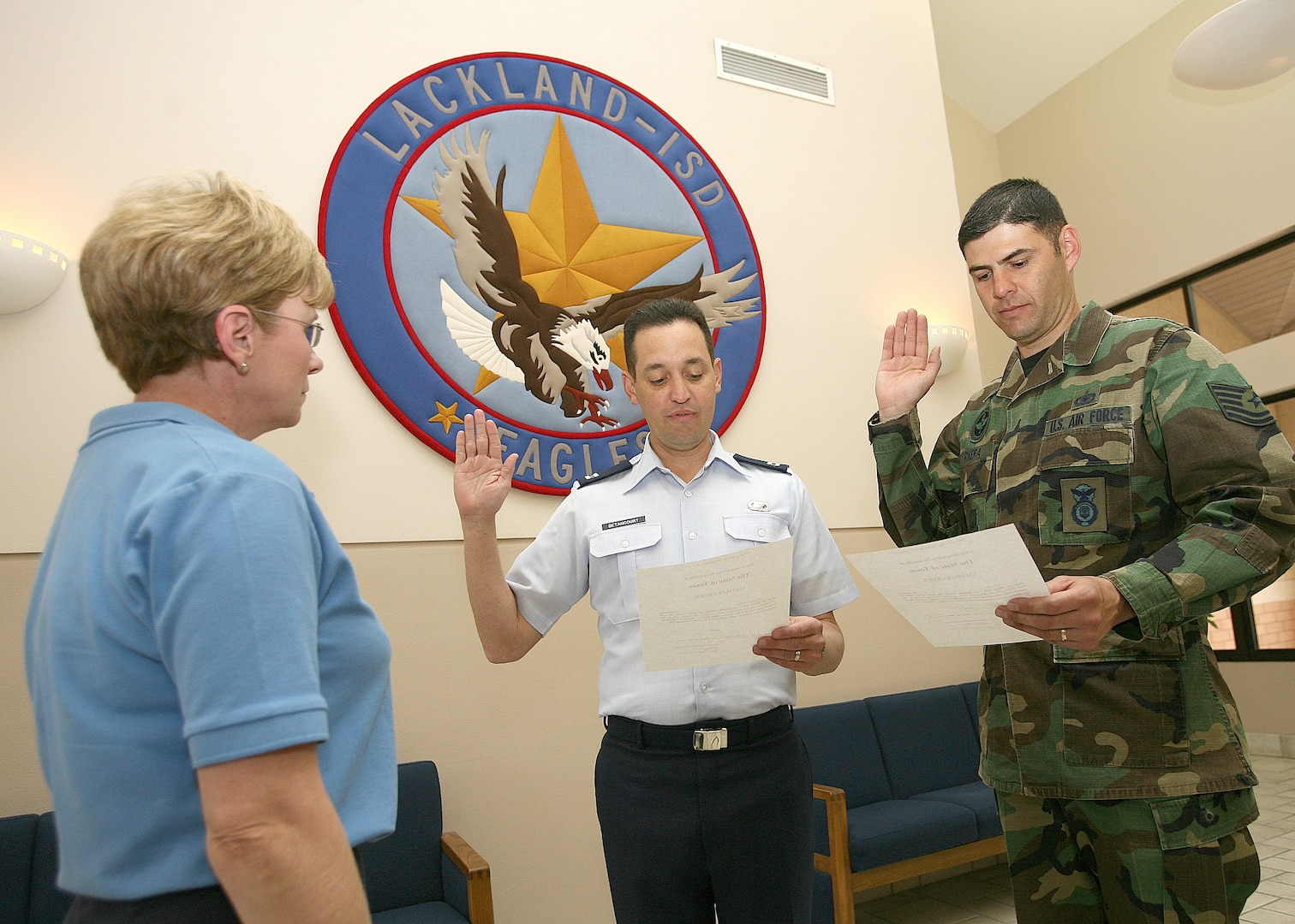 Capt. Angel Betancourt and Tech. Sgt. Luis Rivera, the two newest members of the Lackland Independent School District school board, take the oath of office Feb. 23 in front of Diana Watkins, the LISD administrative assistant. (USAF photo by Robbin Cresswell)