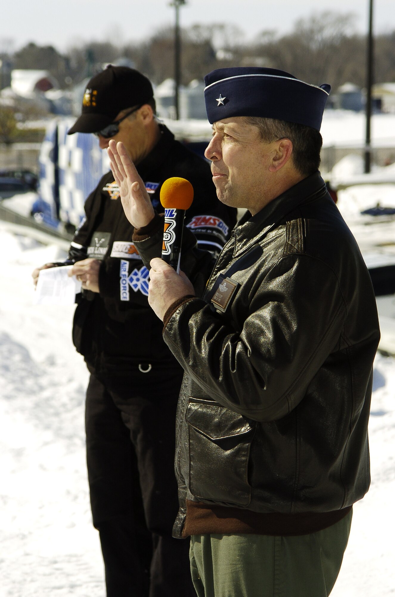 Brig. Gen. Gregory Feest, Deputy Director for Force Application, Directorate of Force Structure, Resources and Assessment, Joint Staff, Washington, D.C., administers the oath enlistment to 17 Air Force Delayed Entry Program members at the Air Force Canterbury Snocross event in Shakopee, Minnesota, March 4.  (Photo courtesy of Mike Roth, Maxim Graphics)