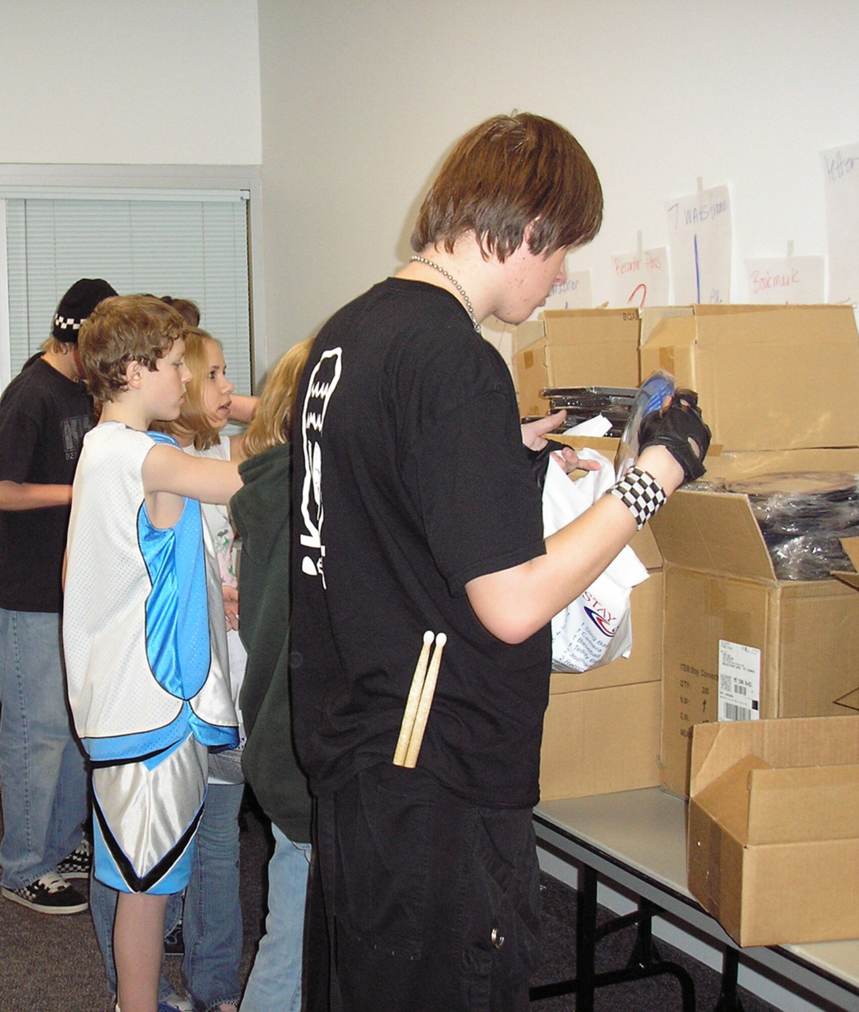 Members of the Keystone Club unpack boxes filled with items to be stuffed into the 'Stay Connected' backpacks during their monthly community service project.