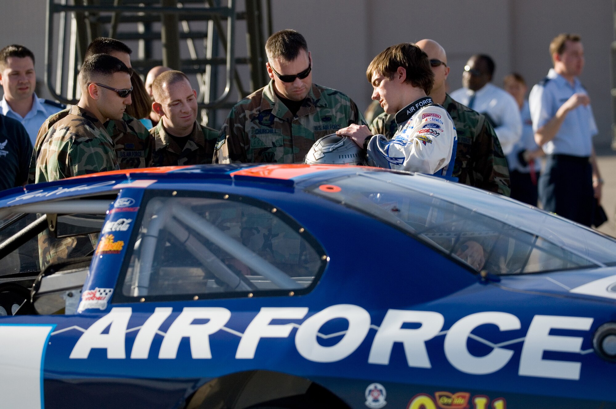Jon Wood, driver of the Air Force car, shows his racing helmet to crew chiefs from the 57th Wing, Nellis Air Force Base, Nev., March 8.  Jon was at Nellis visiting Airmen before his NASCAR Nextel Cup UAW Daimler-Chrysler 400 on Sunday, March 10. (U.S. Air Force Photo by Master Sgt Robert W. Valenca)       
