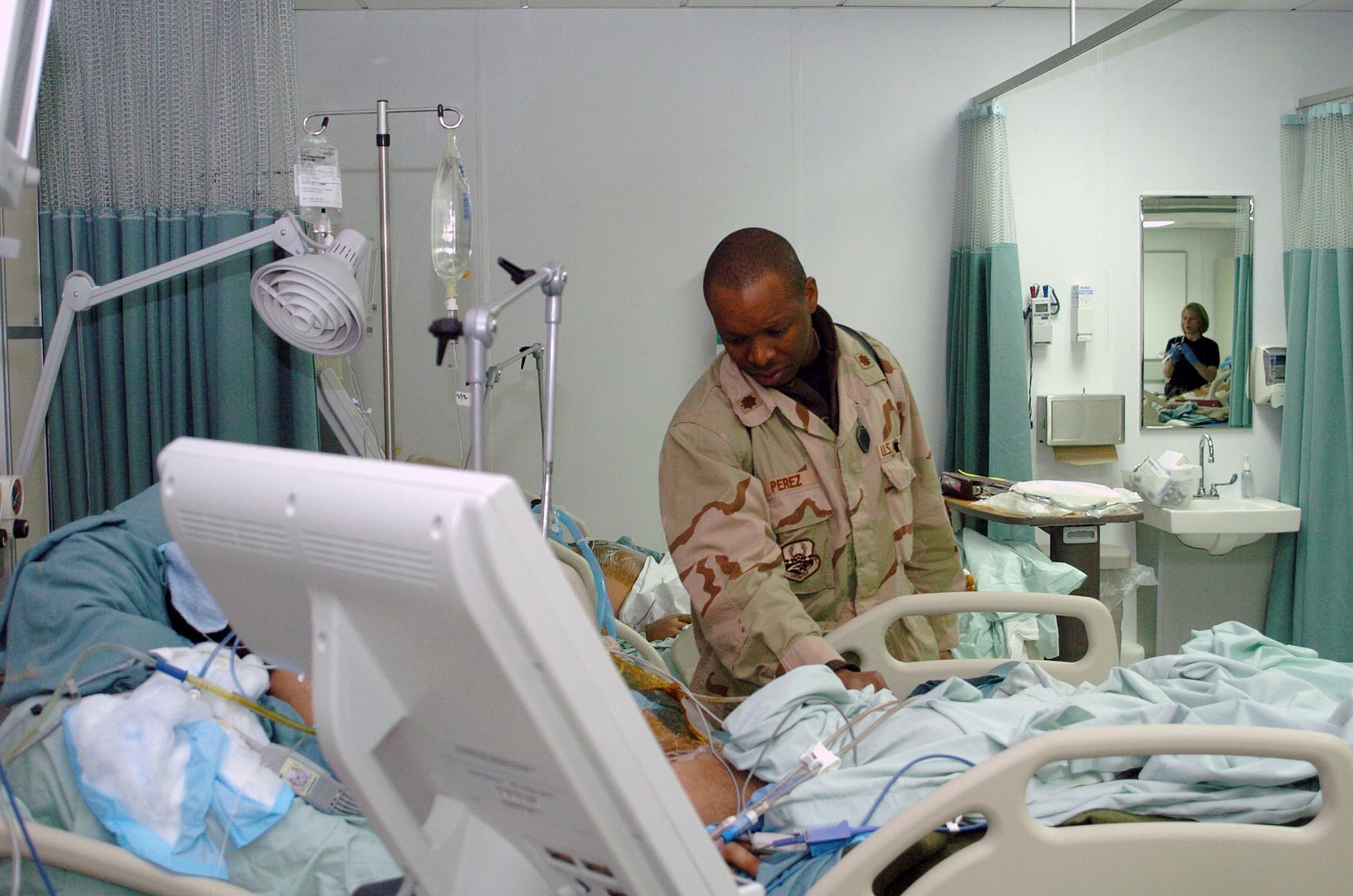 General surgeon Major (Dr.) Clifford Perez, checks on one of his patients March 4 in the new Craig Joint-Theater Hospital at Bagram Air Base, Afghanistan. The new hospital features state-of-the-art equipment comparable to that found in stateside hospitals. (U.S. Air Force photo/Staff Sgt. Thomas J. Doscher) 
