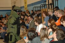 MINOT AIR FORCE BASE, N.D. – An Airman from the 5th Civil Engineer Squadron Explosive Ordnance Disposal team wearing a bomb disposal suit greets students from Memorial Middle School here during an anti-terrorism assembly March 7. Students were briefed about possible threats, how to react to suspicious activities and learned about the various agencies that would respond if the school had an emergency situation. (U.S. Air Force photo by Senior Airman Stacy Moless)  