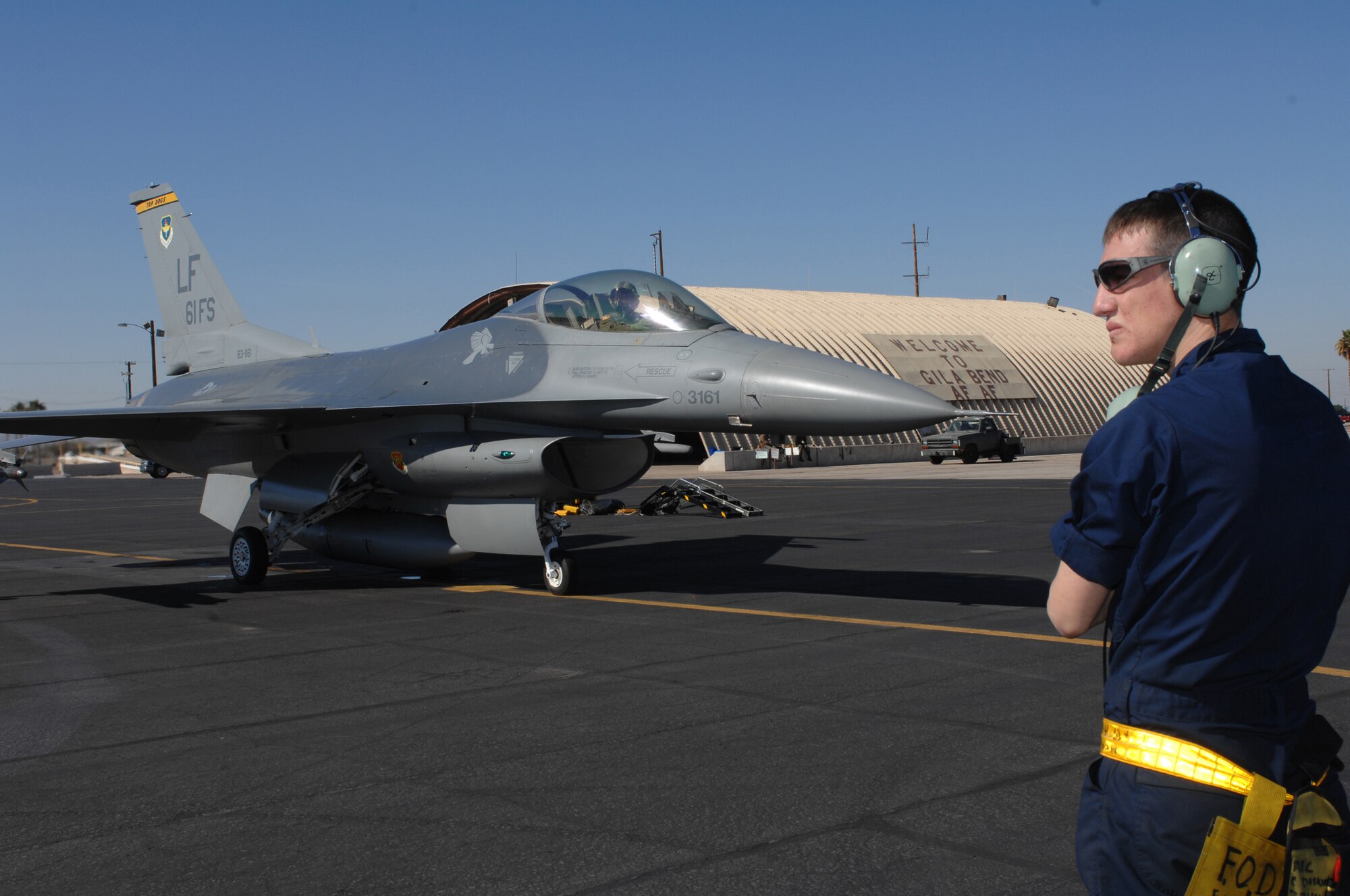 Airman 1st Class Cody Duskin, 61st Aircraft Maintenance Unit assistant dedicated crew chief, martials an F-16 during
tactical intercept pilot training Feb. 22 at the Barry M. Goldwater Range.