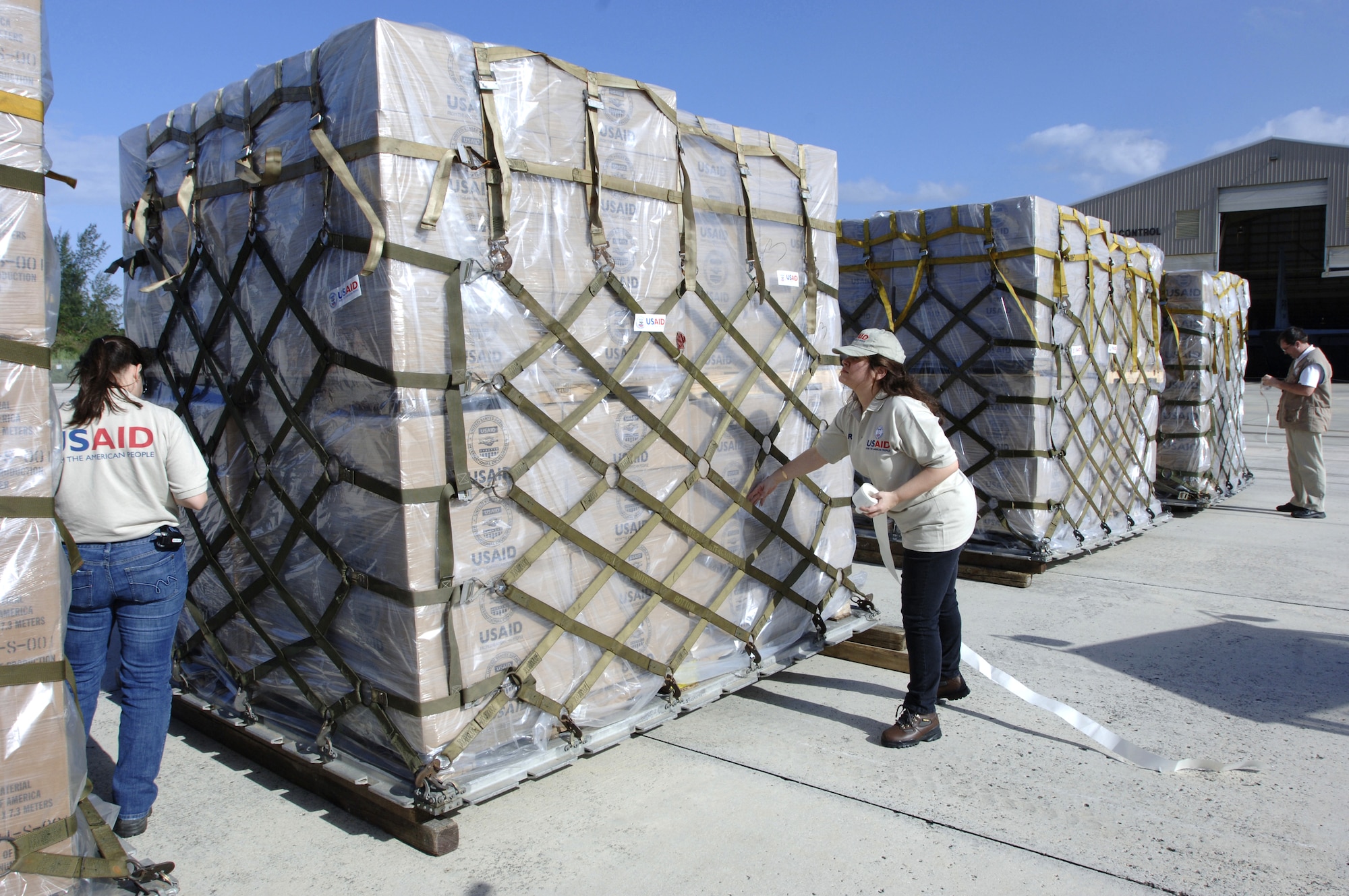 Personnel from the United States Agency for International Development place identifying stickers on humanitarian supplies March 4 in San Juan, Puerto Rico. U.S. Southern Command, in cooperation with USAID, is delivering humanitarian supplies in response to devastating floods in eastern Bolivia. (U.S. Army photo/Spc. Clayton Corey)
