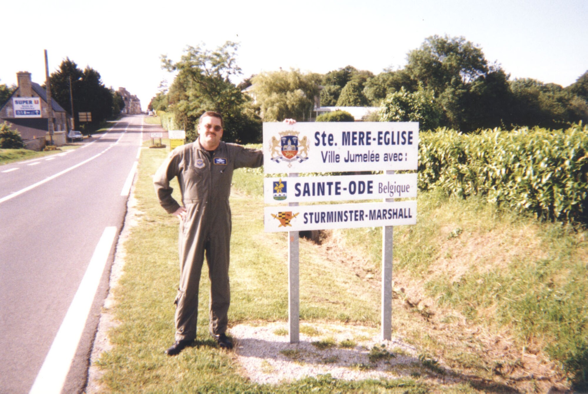 Senior Master Sgt. Jim Crawford stands by a sign at the Ste. Mare, France D-Day Commemorative Airdrops 50th anniversary. (Photo provided Jim Crawford)