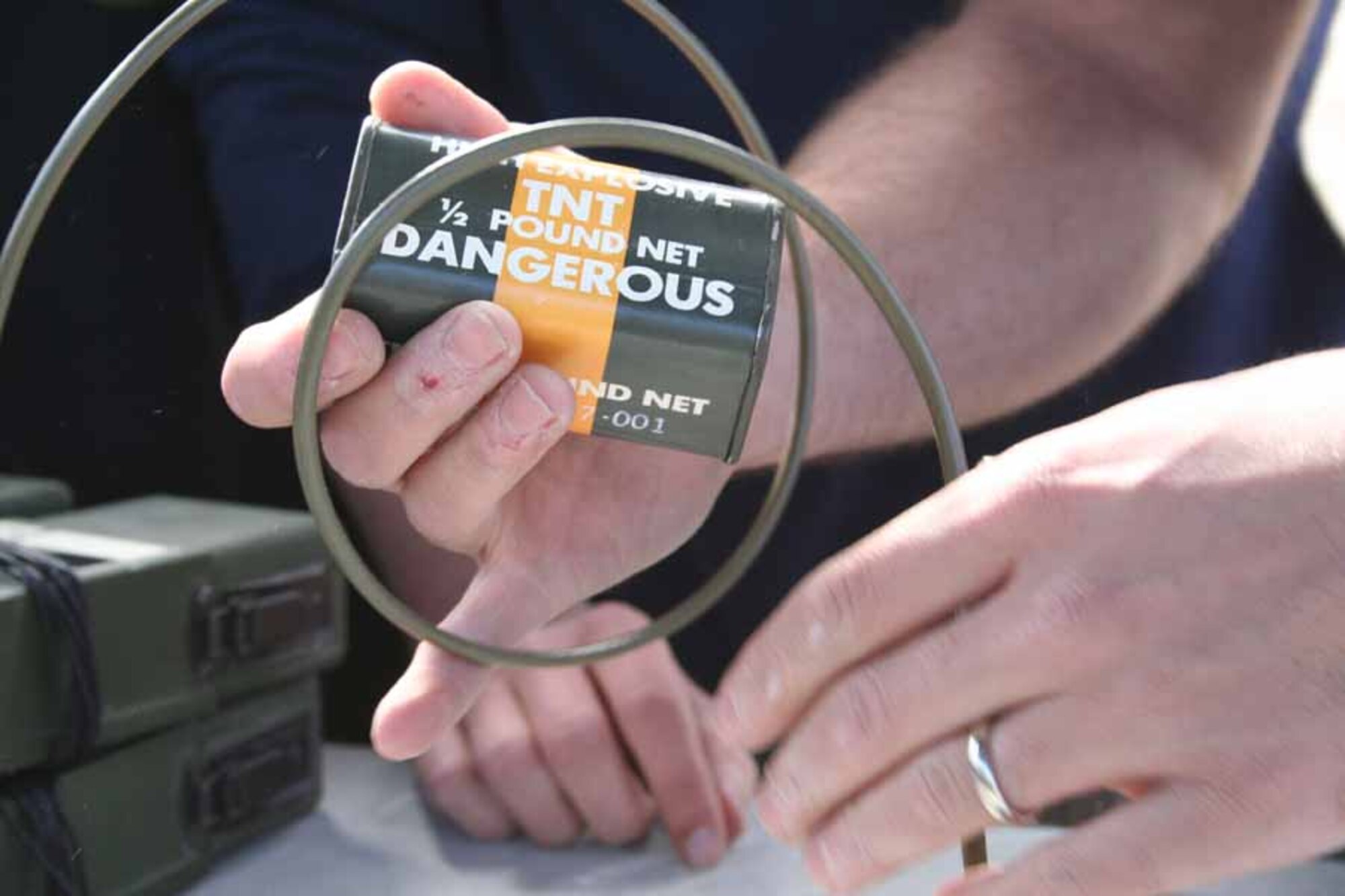 Staff Sgt. Joseph Deslauriers whips a block of TNT with detonating cord. Whipping the TNT provides a means of detonating the explosive without using a blasting cap. (U.S. Air Force photo by Staff Sgt. Angela Shepherd)
