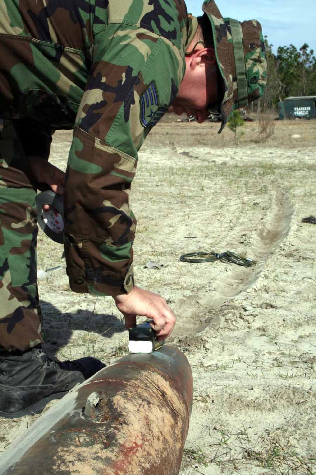 Staff Sgt. Brian Shepherd, 1st Special Operations Civil Engineer Squadron EOD, places an explosive charge on a practice bomb at the Hurlburt Field EOD range. (U.S. Air Force photo by Staff Sgt. Angela Shepherd)