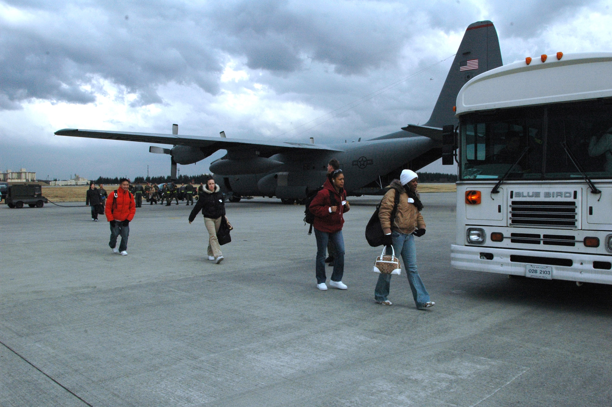 Service members from Kunsan Air Base, Korea, playing non-combatant evacuees, walk along the Yokota Air Base, Japan, flight line. The role players were assisting March 6 in an operational readiness inspection. (U.S. Air Force photo/Master Sgt. Dominique Brown)