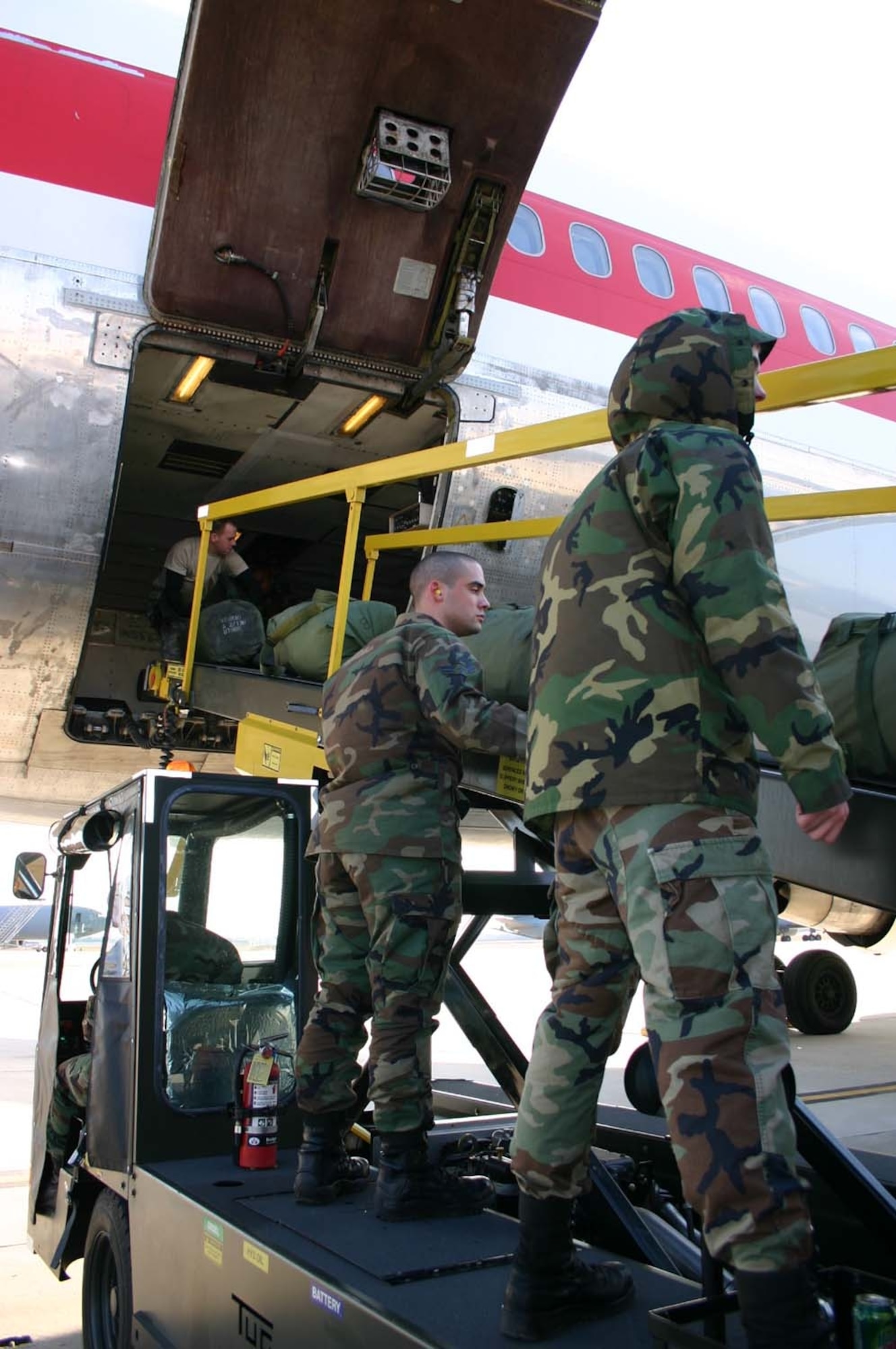 Airmen from the 305th Aerial Port Squadron Passenger Terminal work with Army Soldiers to load the bags of nearly 300 deploying Soldiers Saturday.