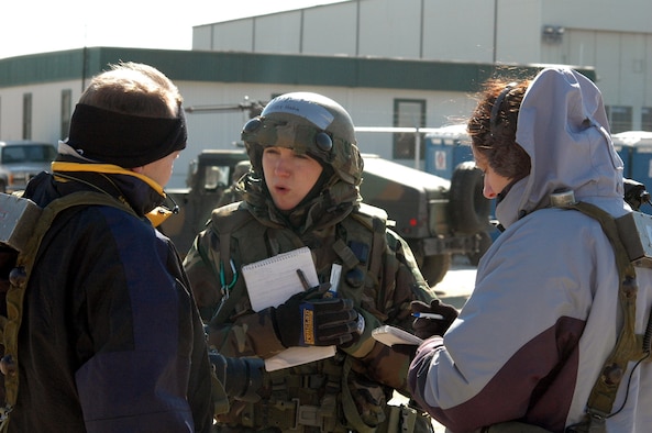 First Lt. Lindsay Hahn, public affairs officer from Travis Air Force Base, Calif., talks with "host nation" reporters, played by Tech. Sgt. Ron Rogers, Air Force News Agency, Texas, and Master Sgt. Melissa Phillips, Dover Air Force Base, Del., during a scenario for Air Force Exercise Eagle Flag 07-3 Feb. 10.  The exercise, operated by the Air Mobility Warfare Center's 421st Combat Training Squadron, tests and trains more than 400 Airmen on their expeditionary combat support skills.  