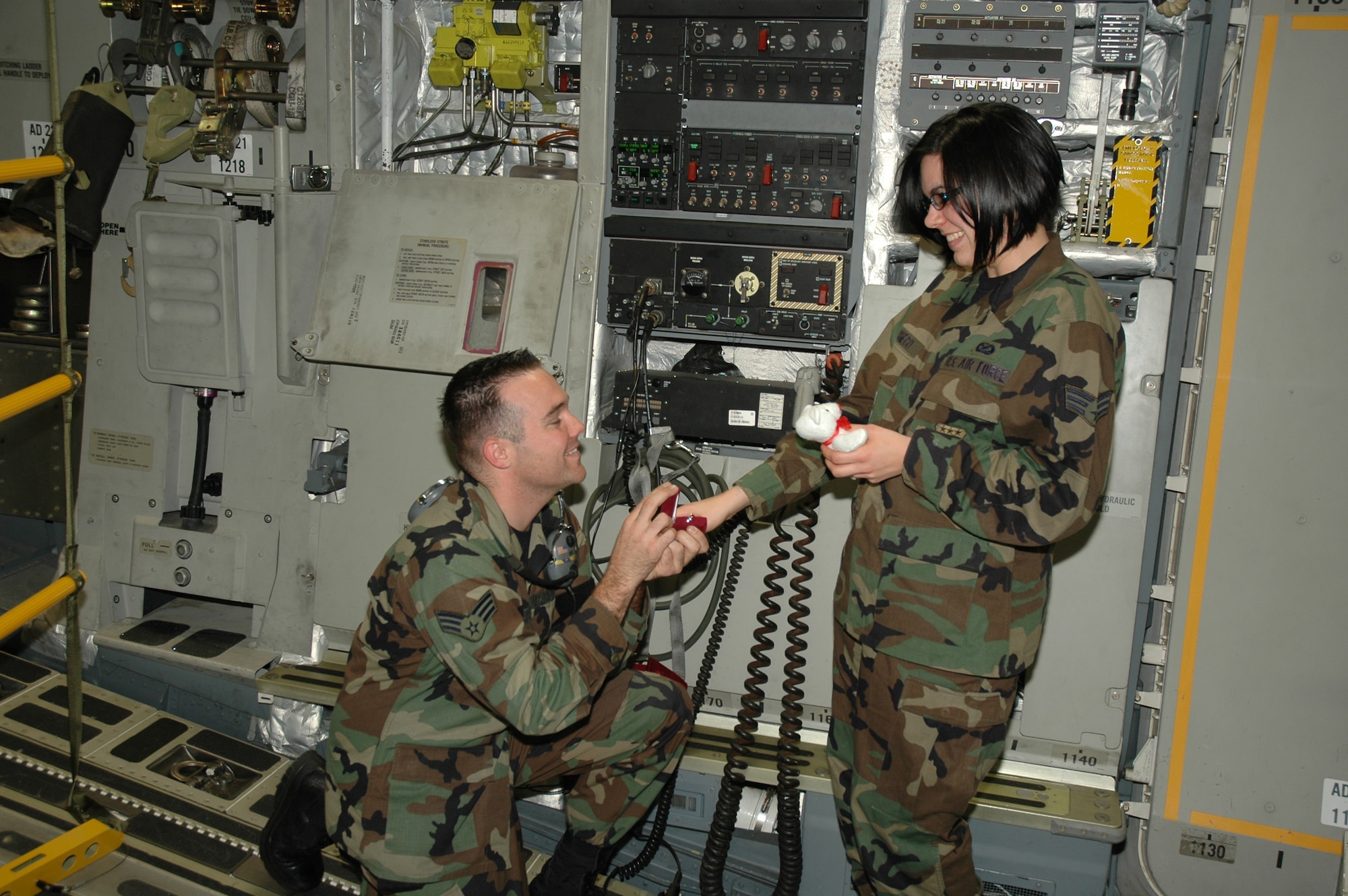 Romance is in the air (and in the jet) -- Senior Airman Chris Shea, with the 315th Aircraft Maintenance Squadron, proposes to Senior Airman Dani Pacheco, 315th Public Affairs, in the back of a C-17 Globemaster III.  Both reservists are members of the 315th Airlift Wing at Charleston AFB, S.C. (Photo by Tech. Sgt. Mark Kleber, USAFR)